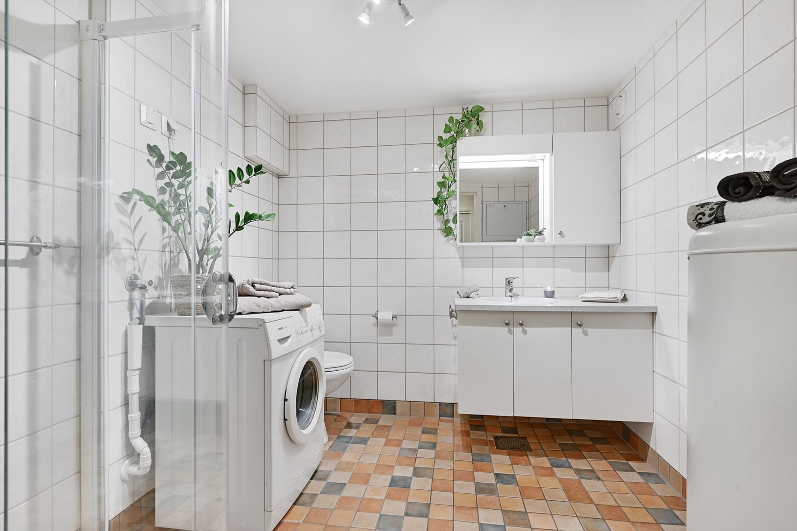 Fliselagt bad/wc med varmekabler, dusjhjørne, toalett, servant med underskap, opplegg vaskemaskin og varmtvannsbereder. Galleribilde