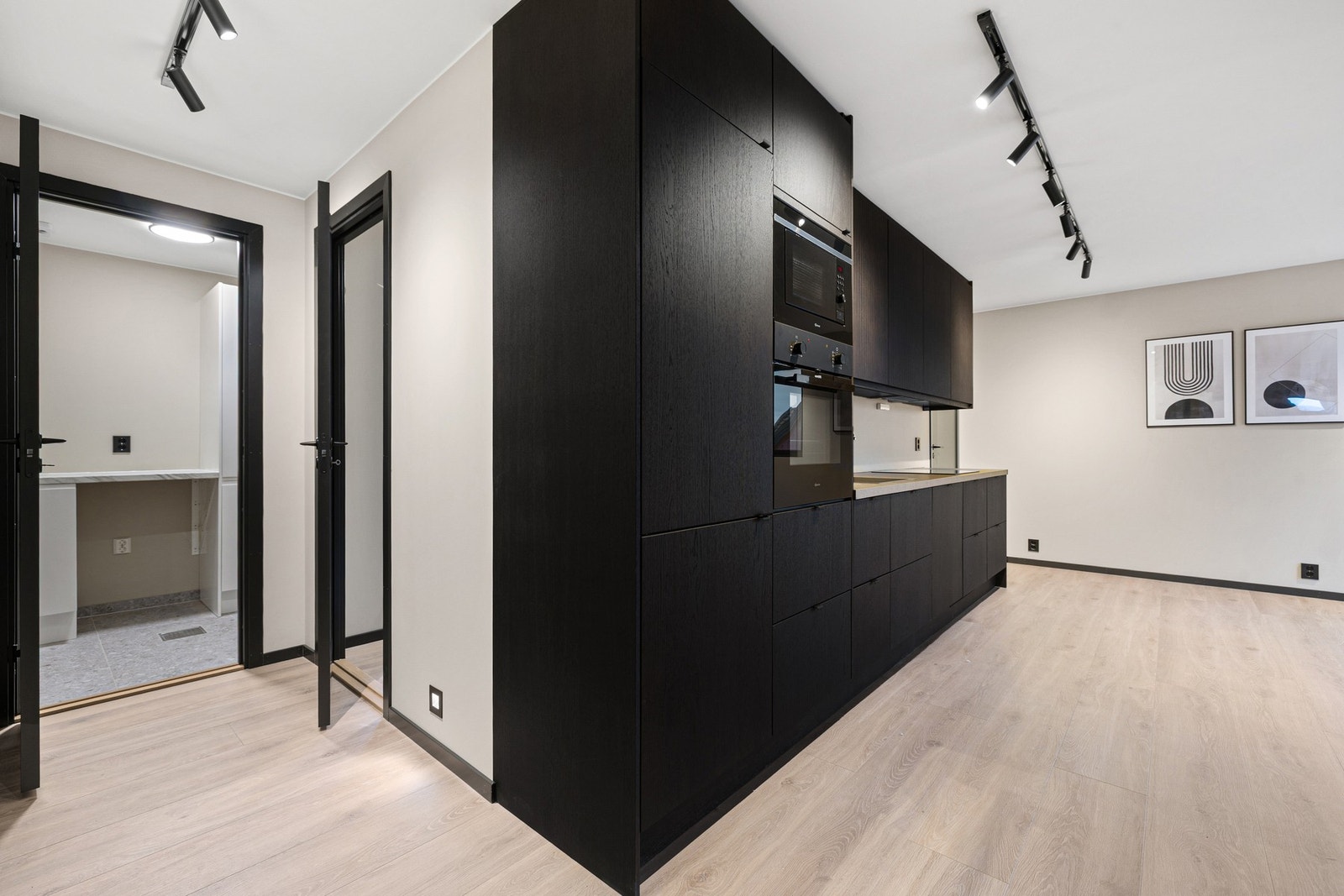 Gjennomgående mørke detaljer gir leiligheten et helhetlig og stilrent preg. Galleribilde