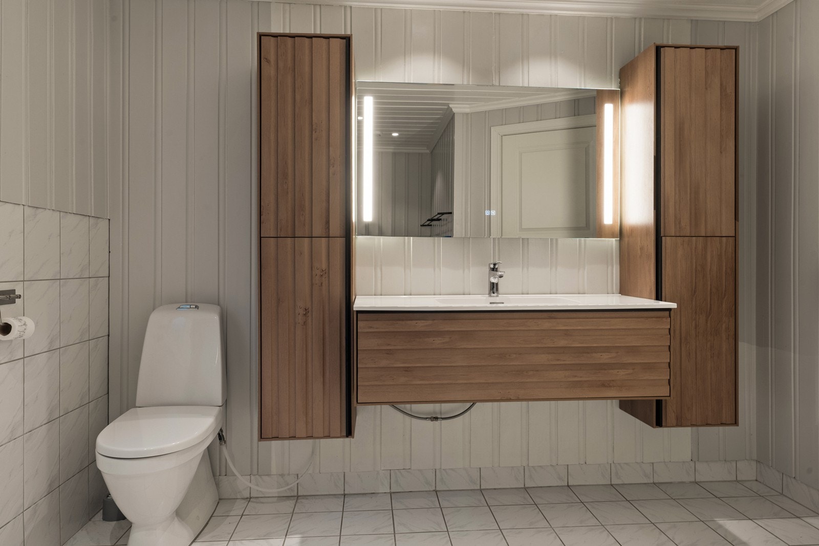 Baderomsinnredning med nedfelt servant og sideskap gir god oppbevaring. Galleribilde