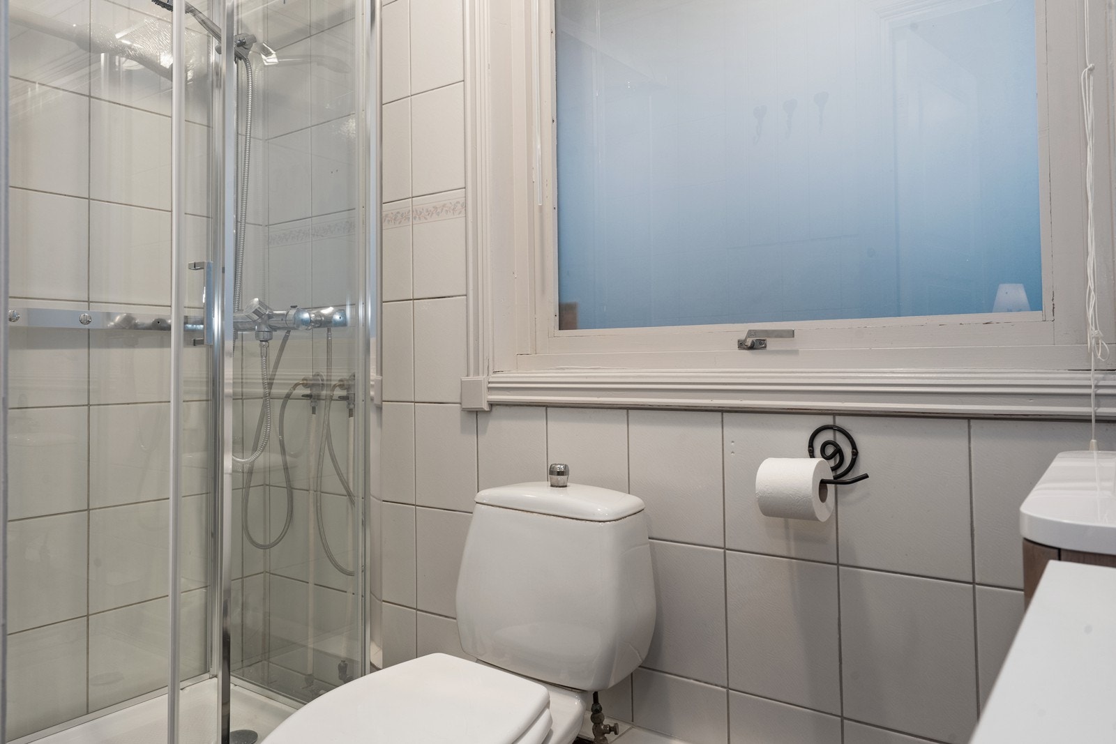 Flislagte overflater og dusjkabinett gir praktisk våtromsløsning. Galleribilde