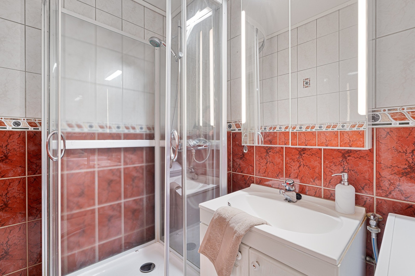 Badet har varme i gulv og et dusjkabinett som sikrer trygg avrenning til sluk. Galleribilde