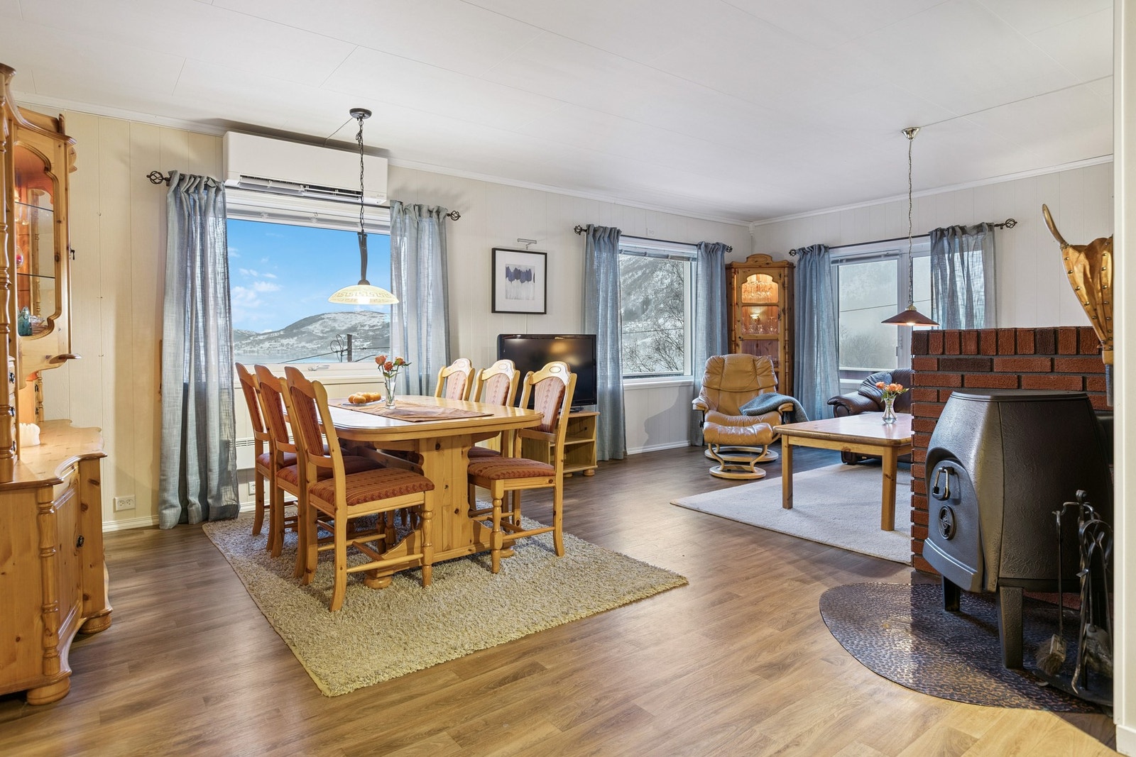 Romslig stue med både varmepumpe og vedfyring som oppvarmingskilde. Galleribilde