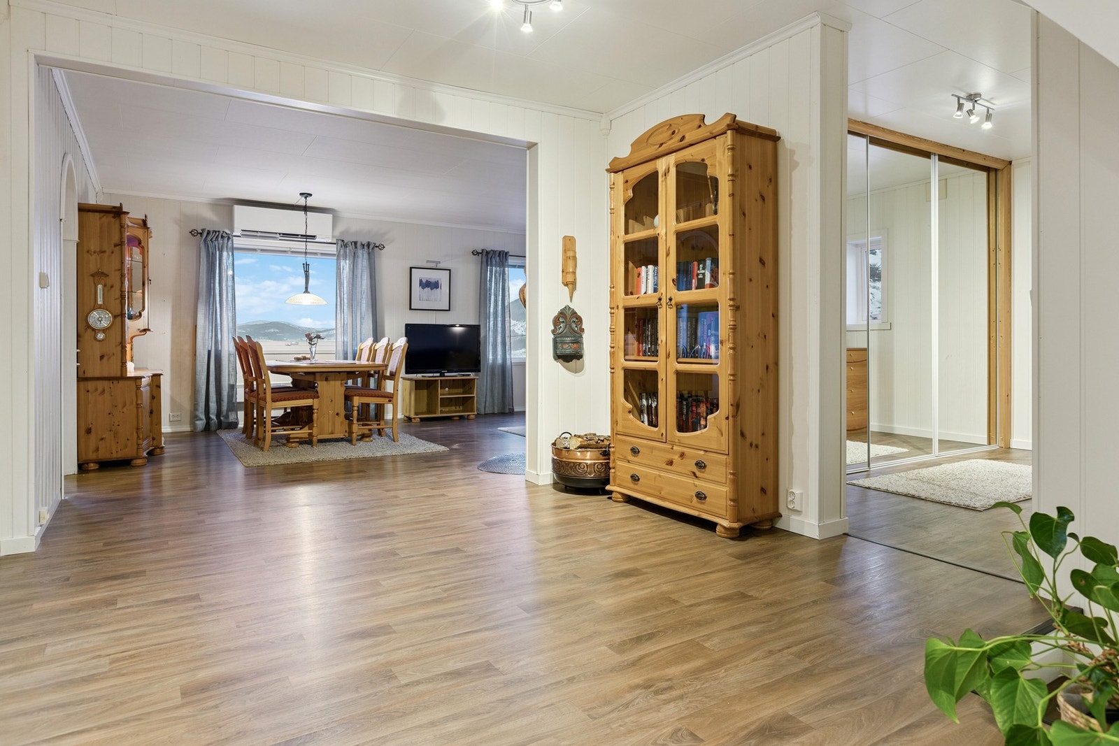 Gang og stue med gode oppbevaringsmuligheter i skyvedørsgarderobe. Galleribilde