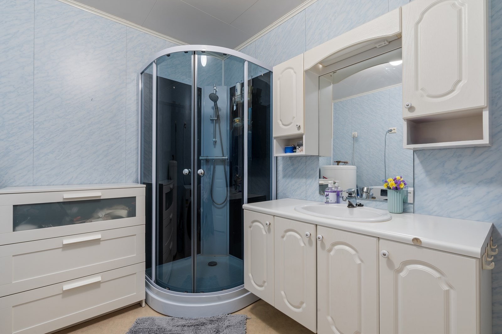 Bad med baderomsinnredning, dusjkabinett, toalett og opplegg for vaskemaskin Galleribilde