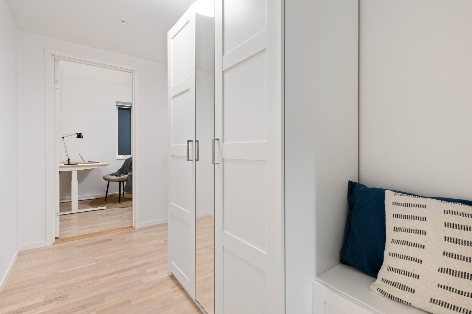 Entré/gang med garderobeskap og sittebenk. Pent parkettgulv. Dør til soverom. Galleribilde