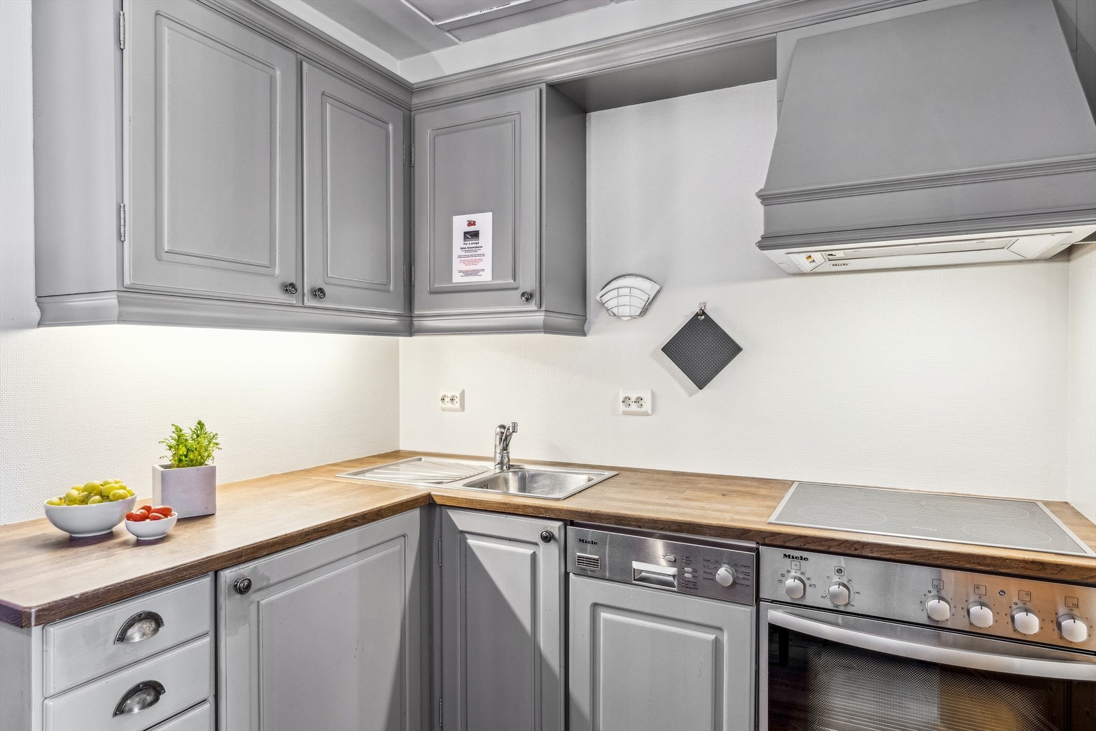 Kjøkkenet har godt med benk- og skapplass, og integrerte hvitevarer som platetopp, komfyr, oppvaskmaskin og kjøleskap. Galleribilde