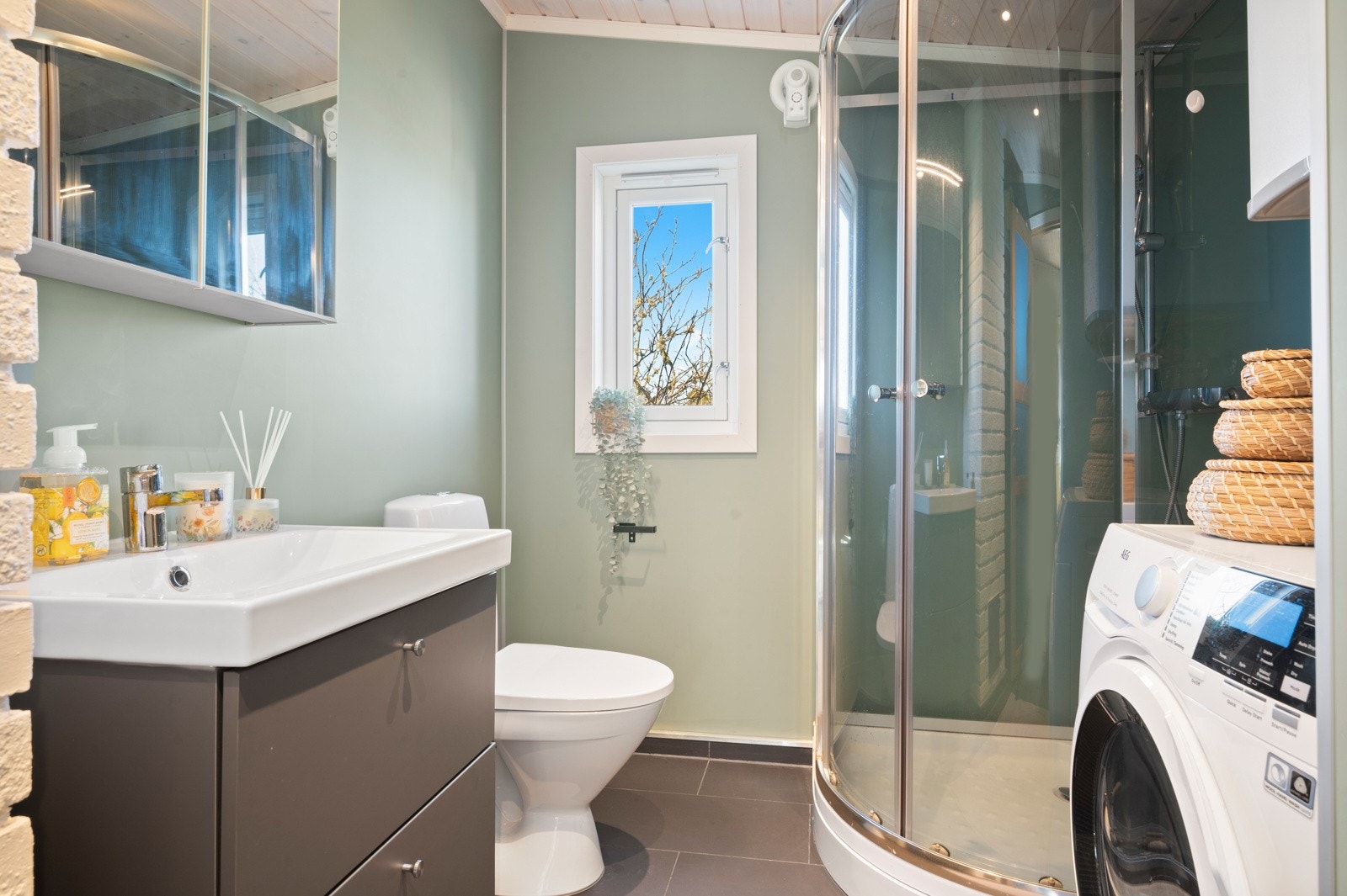 Innredningen består av utslagsvask med speil, dusjkabinett, toalett og opplegg for vaskemaskin Galleribilde