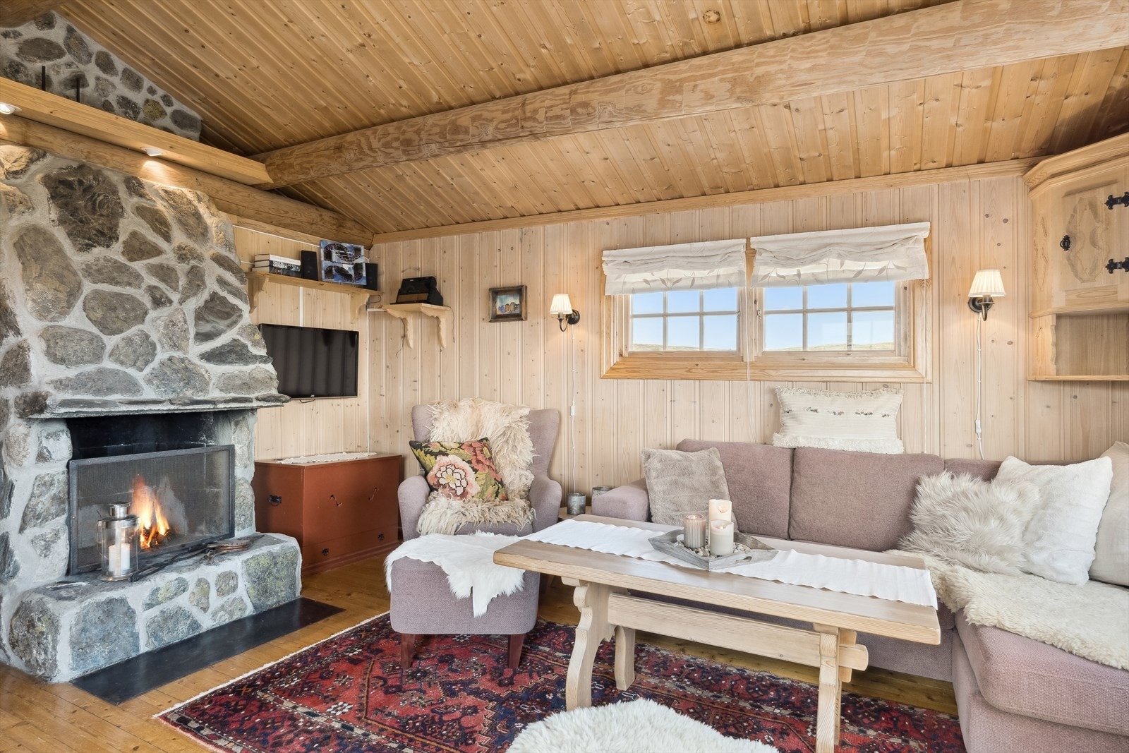 I stua er det mønet himling med flotte tømmeråser, og en plassmurt peis forblendet med naturstein gir en hyggelig stemning til rommet. Galleribilde