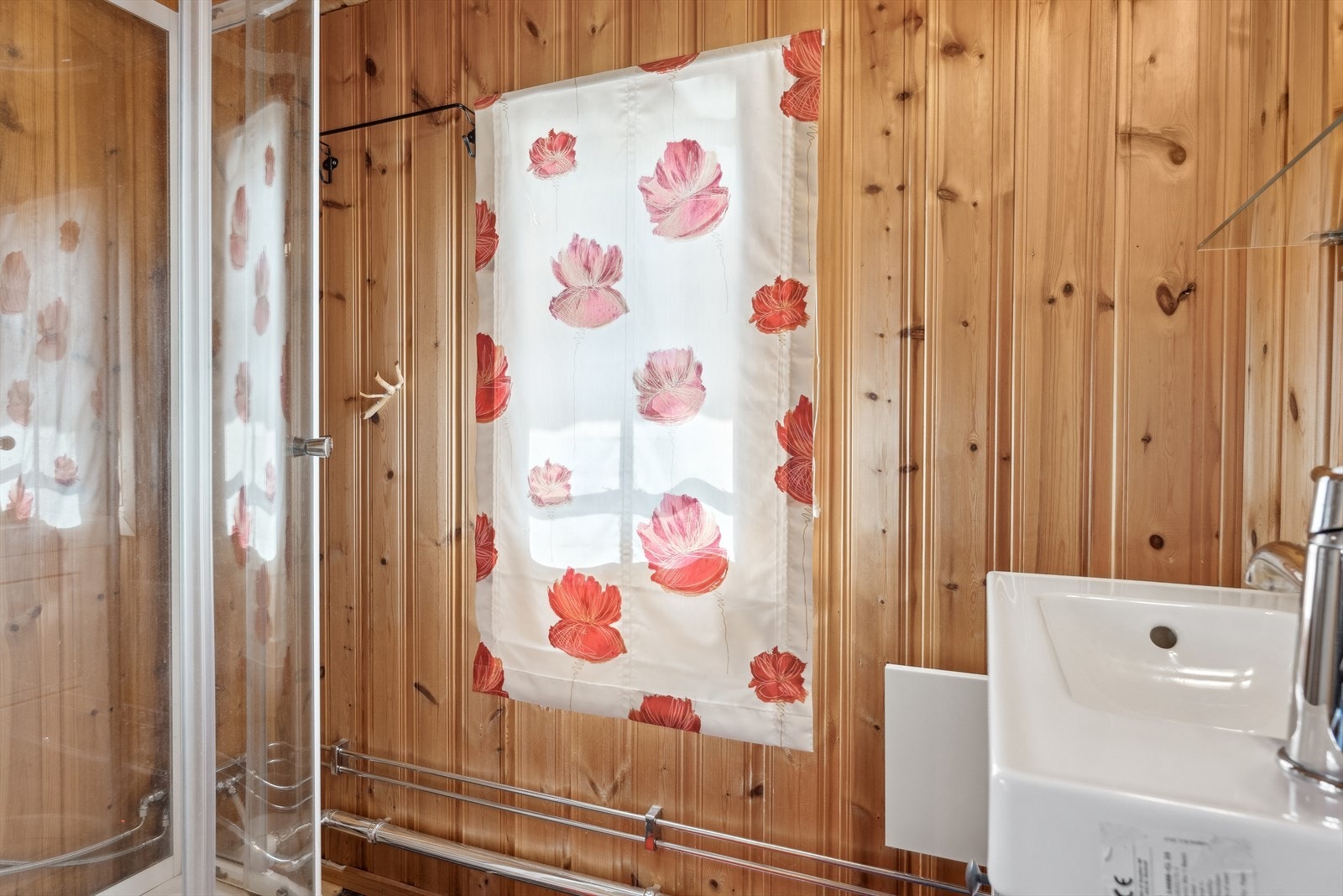 På badet er det flislagt gulv, mens det på veggene er panel. Her er det servantskap med heldekkende servant og det er frittstående dusjkabinett. Galleribilde