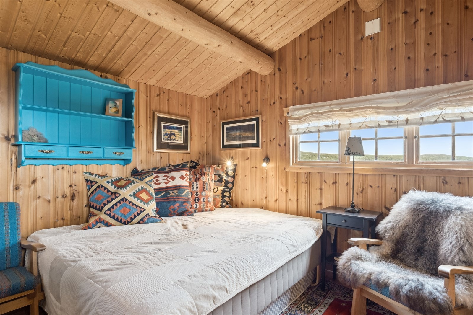 I anneksdelen er det lyst og romslig soverom med mønet himling og flotte tømmeråser. Her er det fin plass til dobbeltseng, et liten sittegruppe e.l. En eldre vedovn gir god varme til rommet. Galleribilde