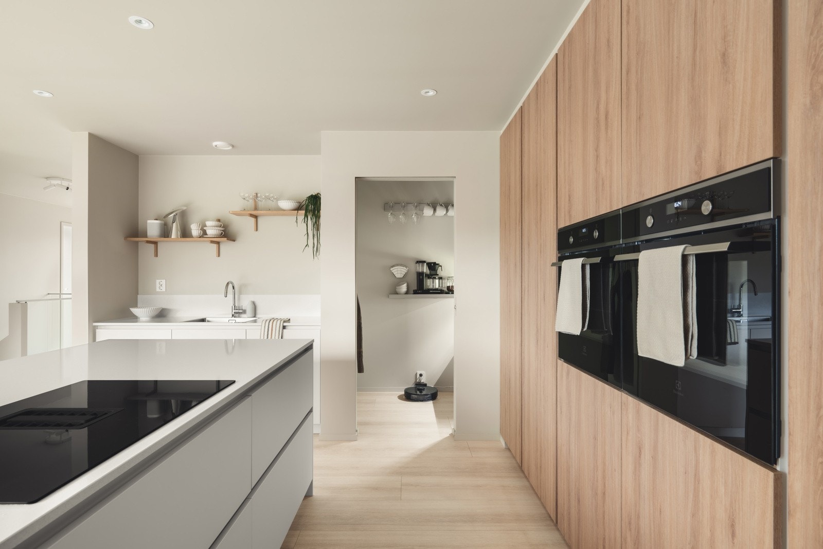 Løsningen er godt utnyttet med høyskap, skuffer og en praktisk kjøkkenøy som gir ekstra arbeidsflate og plass til sosialt samvær. Galleribilde