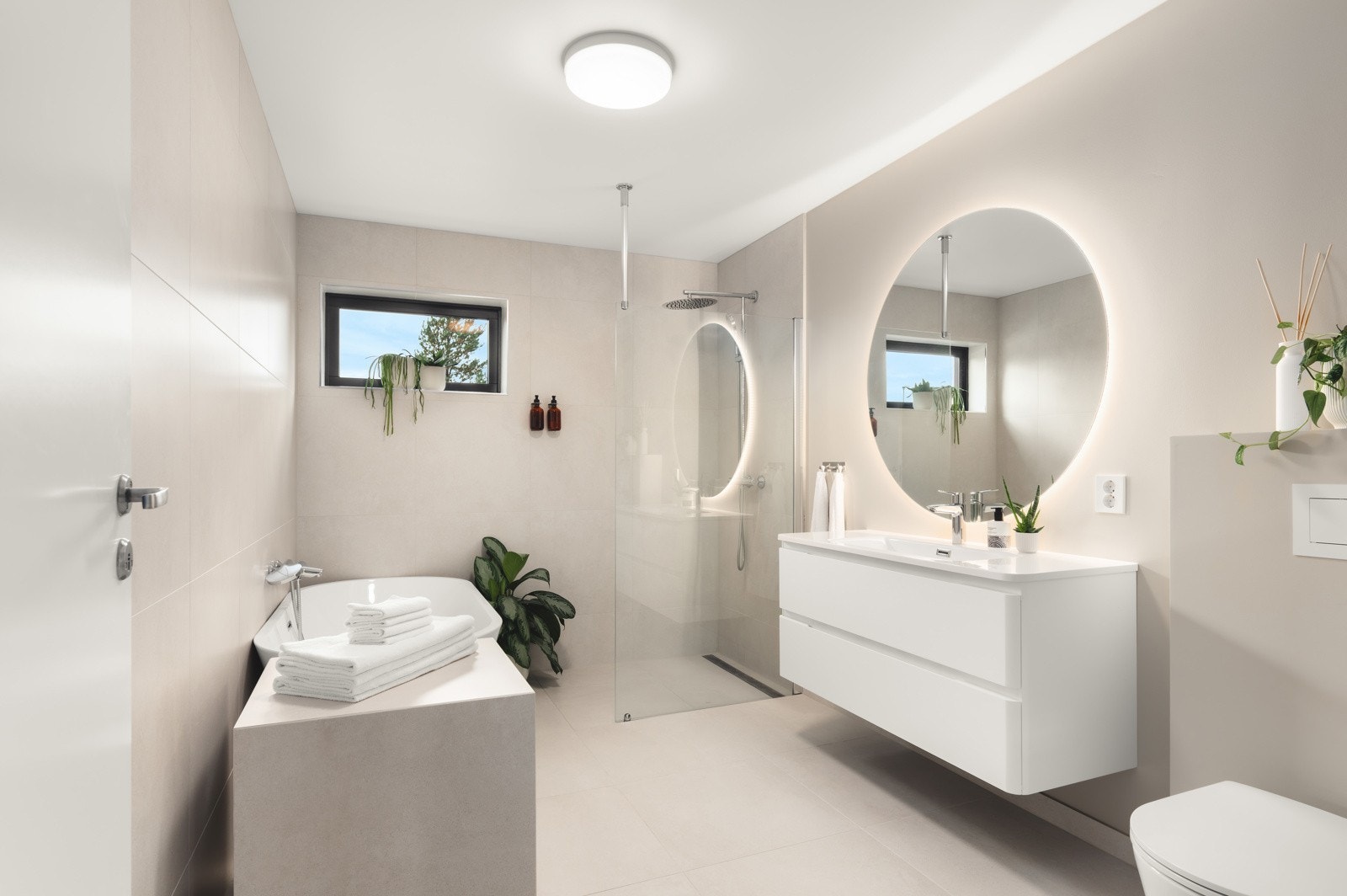 Boligens andre bad byr på både funksjonalitet og velvære. Gulvet er helfliset og utstyrt med elektriske varmekabler som gir en behagelig varme året rundt. Veggene er utført med en kombinasjon av fliser og malte plater som gir et moderne og stilrent preg Galleribilde