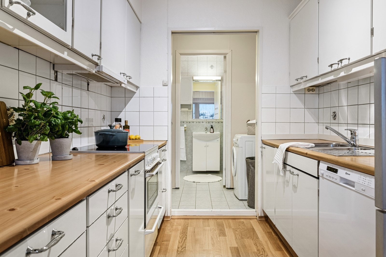 Lyst kjøkken mot vaskerom og baderom. Galleribilde