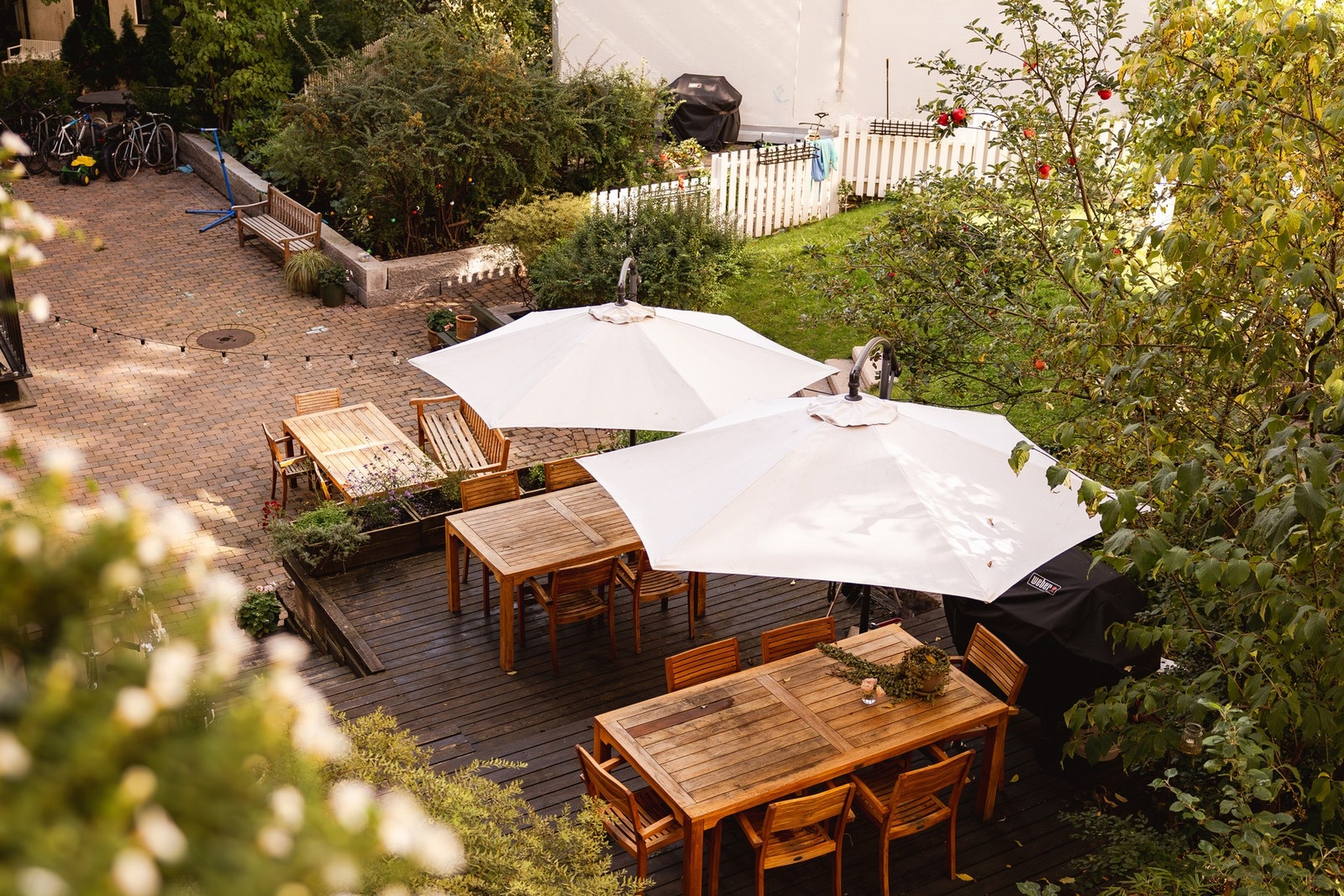 Skjermet bakgård med pent opparbeidede utearealer, gressplen, frodig beplantning og hyggelige sittegrupper. Galleribilde