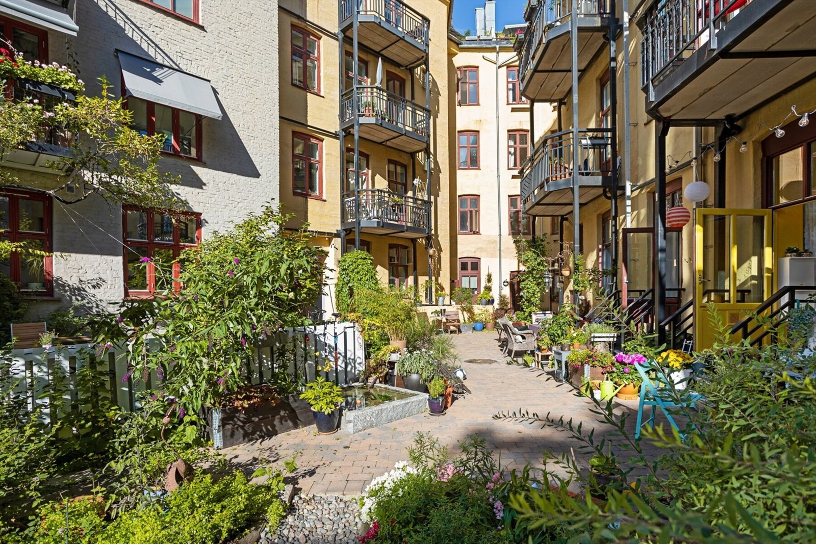 Nærmest som en forlengelse av leiligheten, har man svært enkel adkomst til idyllisk gårdsrom med sittegrupper og fantasitsk fontene. Galleribilde