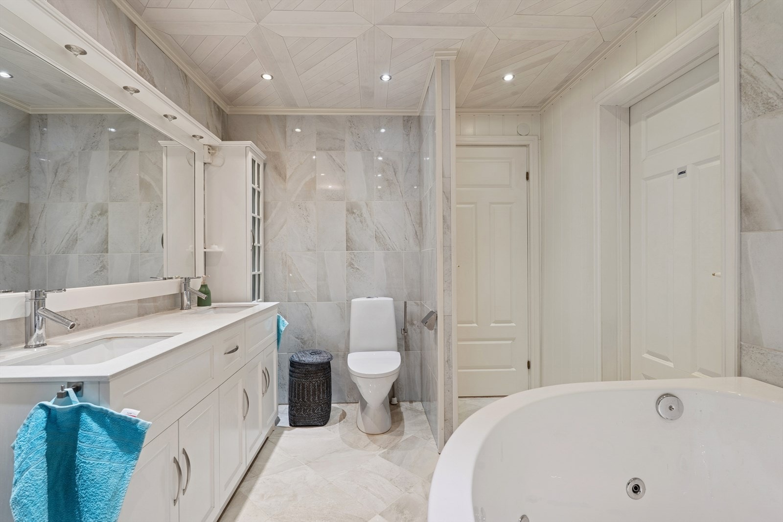 Badet er ellers utstyrt med dusjkabinett, boblebadekar, toalett og baderomsinnredning med dobbel servant. Galleribilde