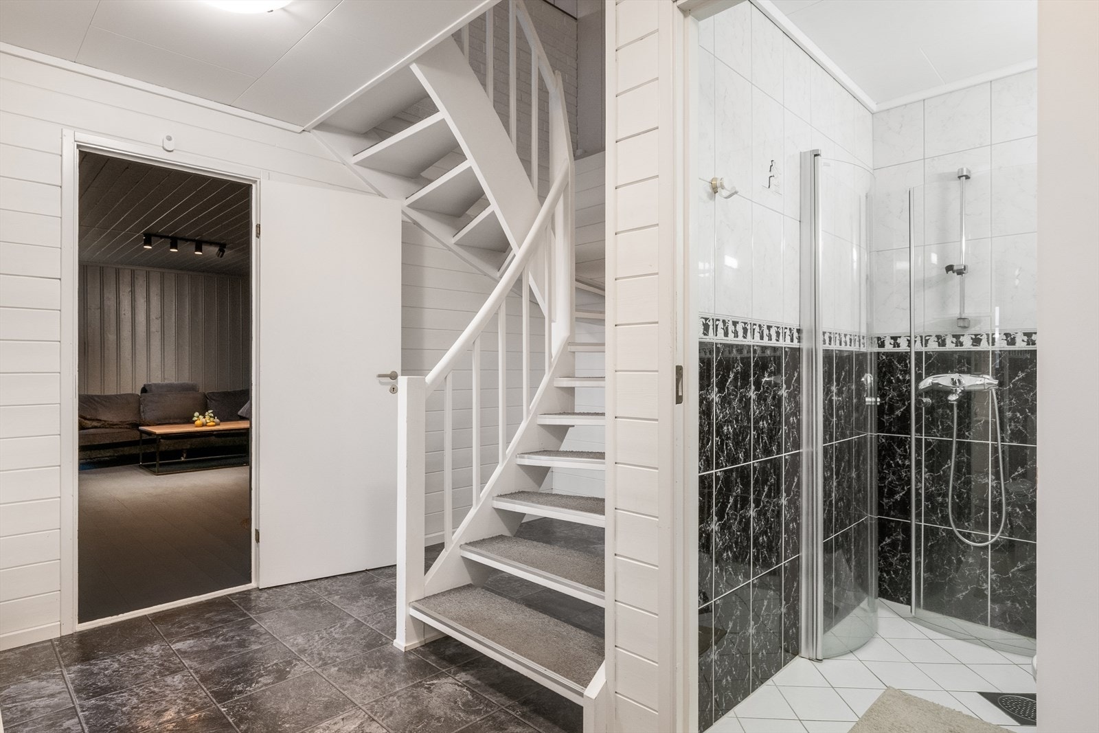 Videre inn i mellomgang og trapperom er flislagt gulv og lyse overflater Galleribilde