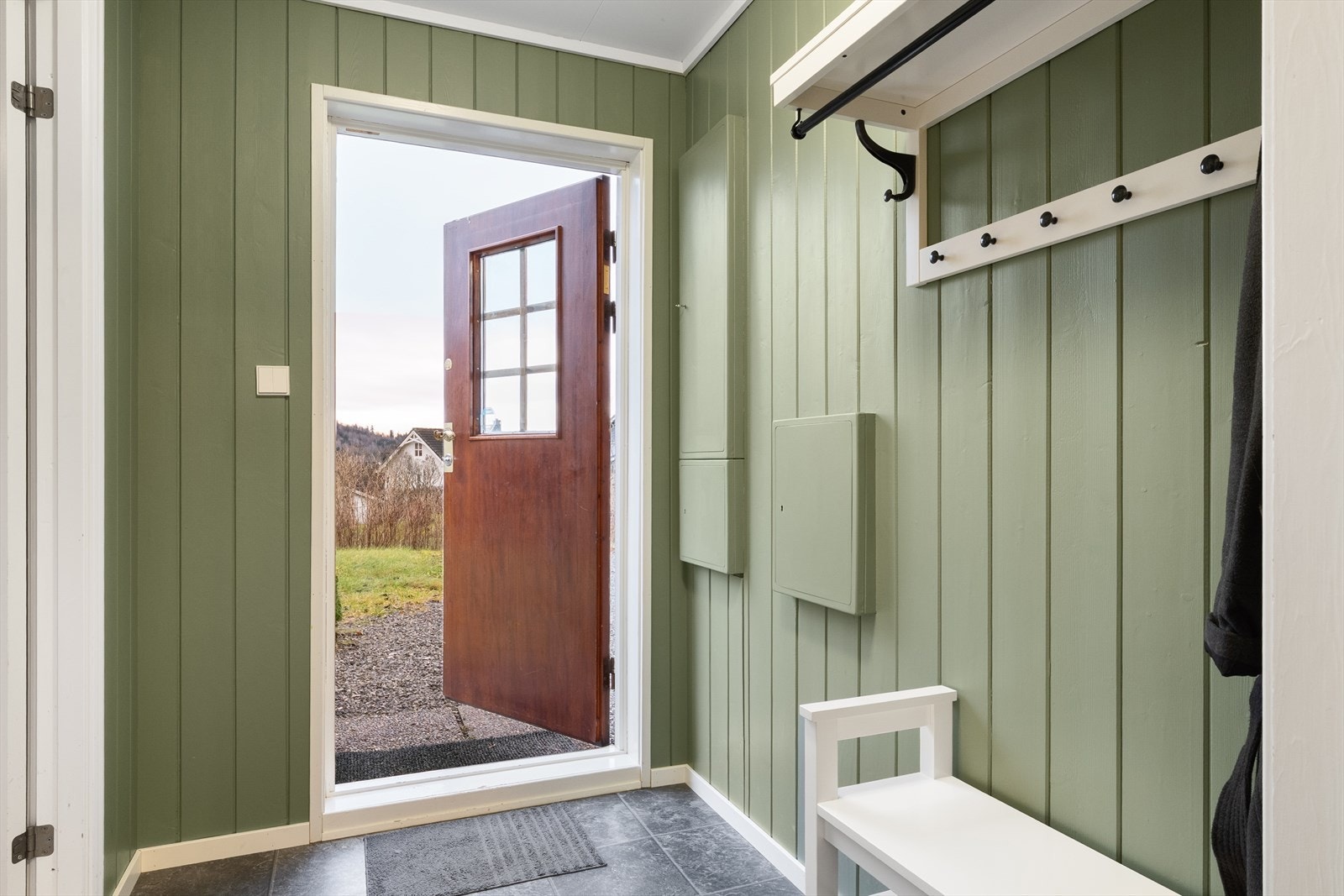 Entréen har praktiske fliser på gulv og plass for yttertøy og sko samt sikringsskap Galleribilde