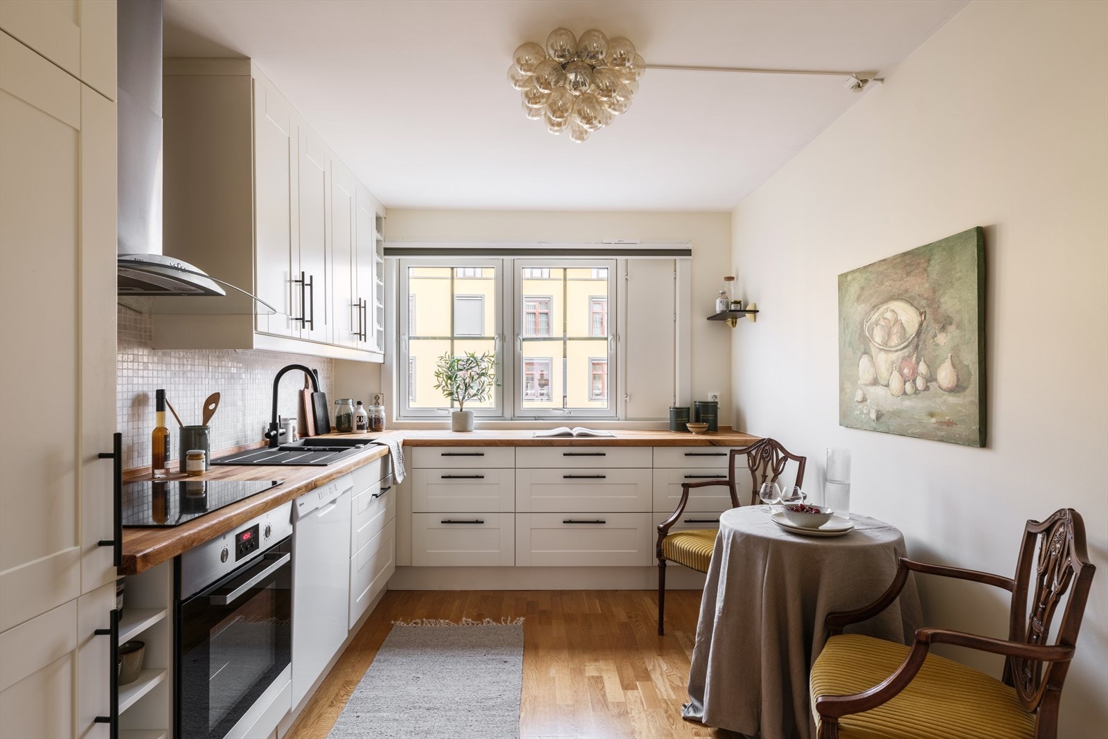 Separat kjøkken med lys og moderne innredning og svarte håndtak Galleribilde