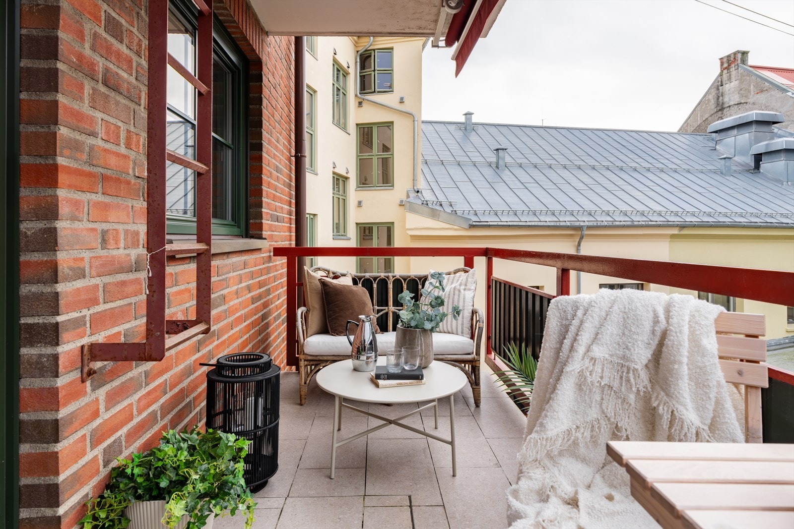 Balkongen har fliser på gulv og markise som kan rulles ut på varme sommerdager Galleribilde