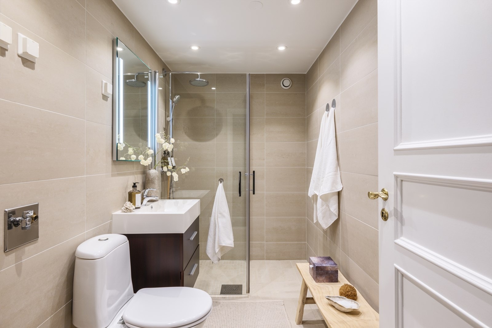 Romslig bad utstyrt med dusjhjørne, wc, opplegg for vaskemaskin og baderomsinnredning Galleribilde