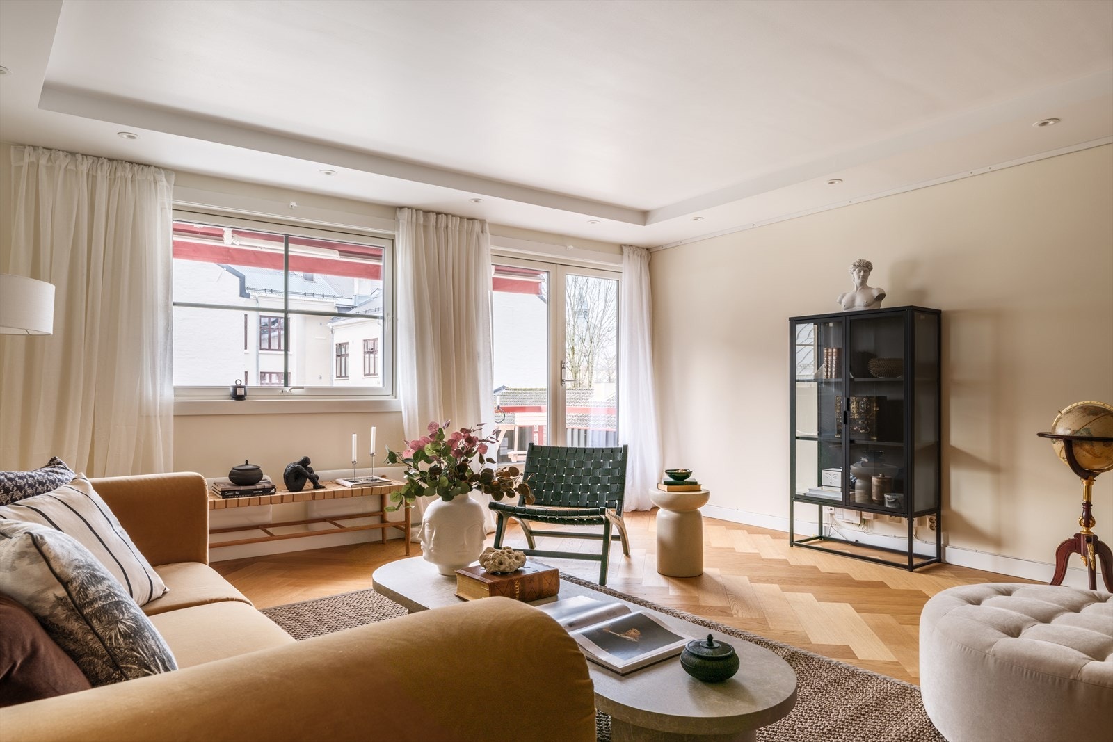 Rosmlig stue med lyse overflater og store vindusflater som slipper inn godt med lys Galleribilde