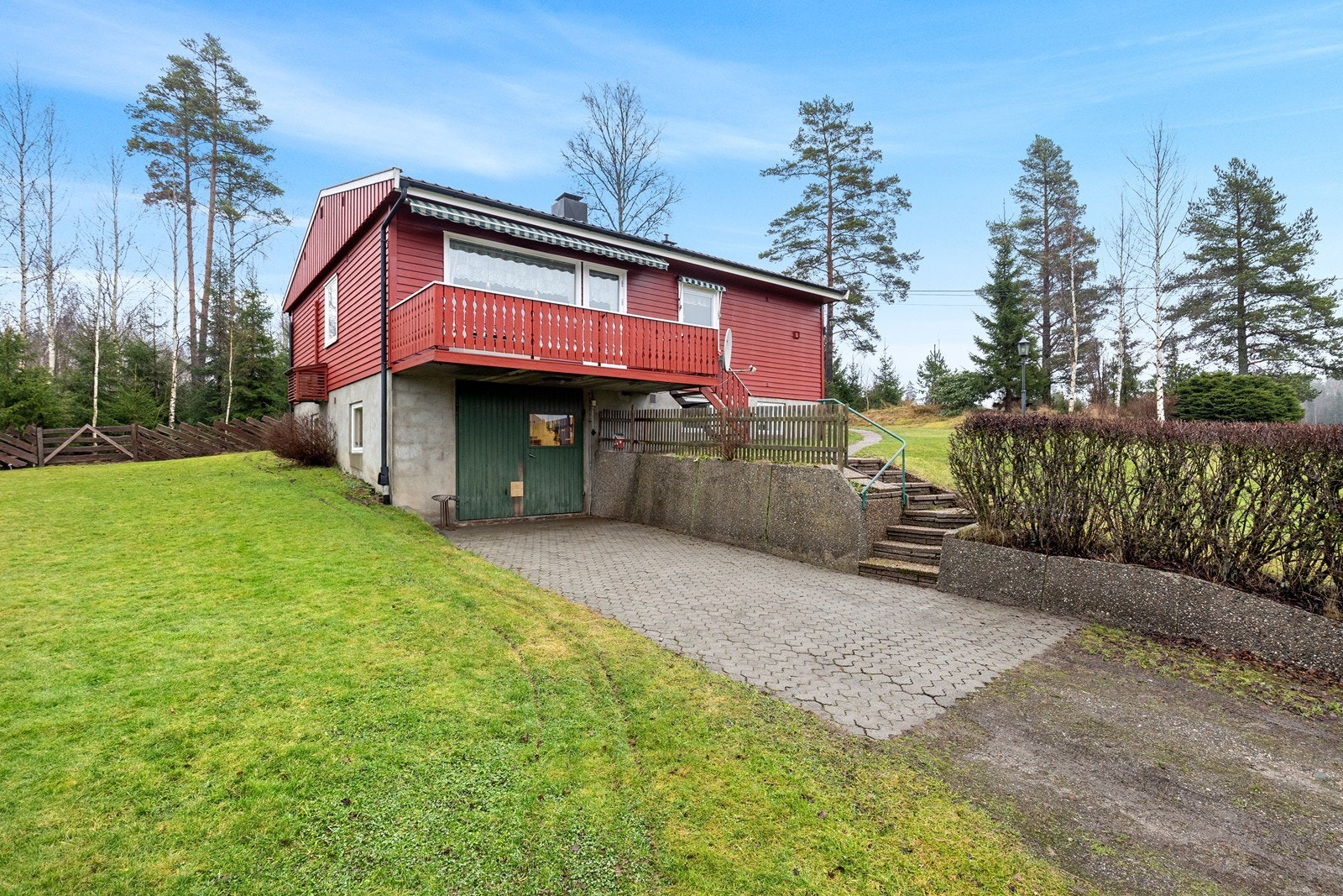 Eneboligen har en veranda på ca. 11 m² med betongdekke og trykkimpregnerte gulvbord, samt malt trevirke på rekkverket. Galleribilde