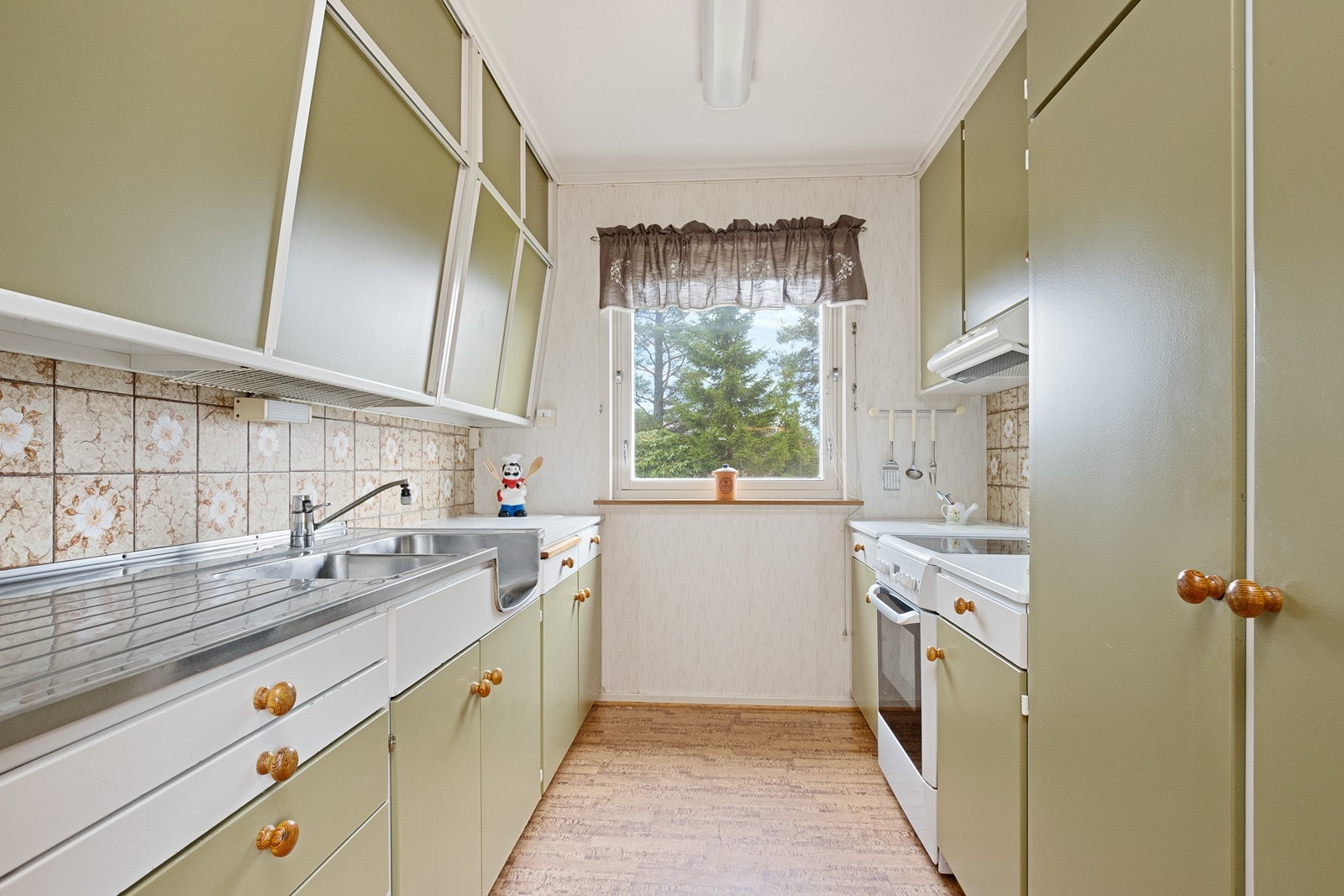 Kjøkkenet har slette, malte fronter og laminerte benkeplater fra byggeåret. Galleribilde