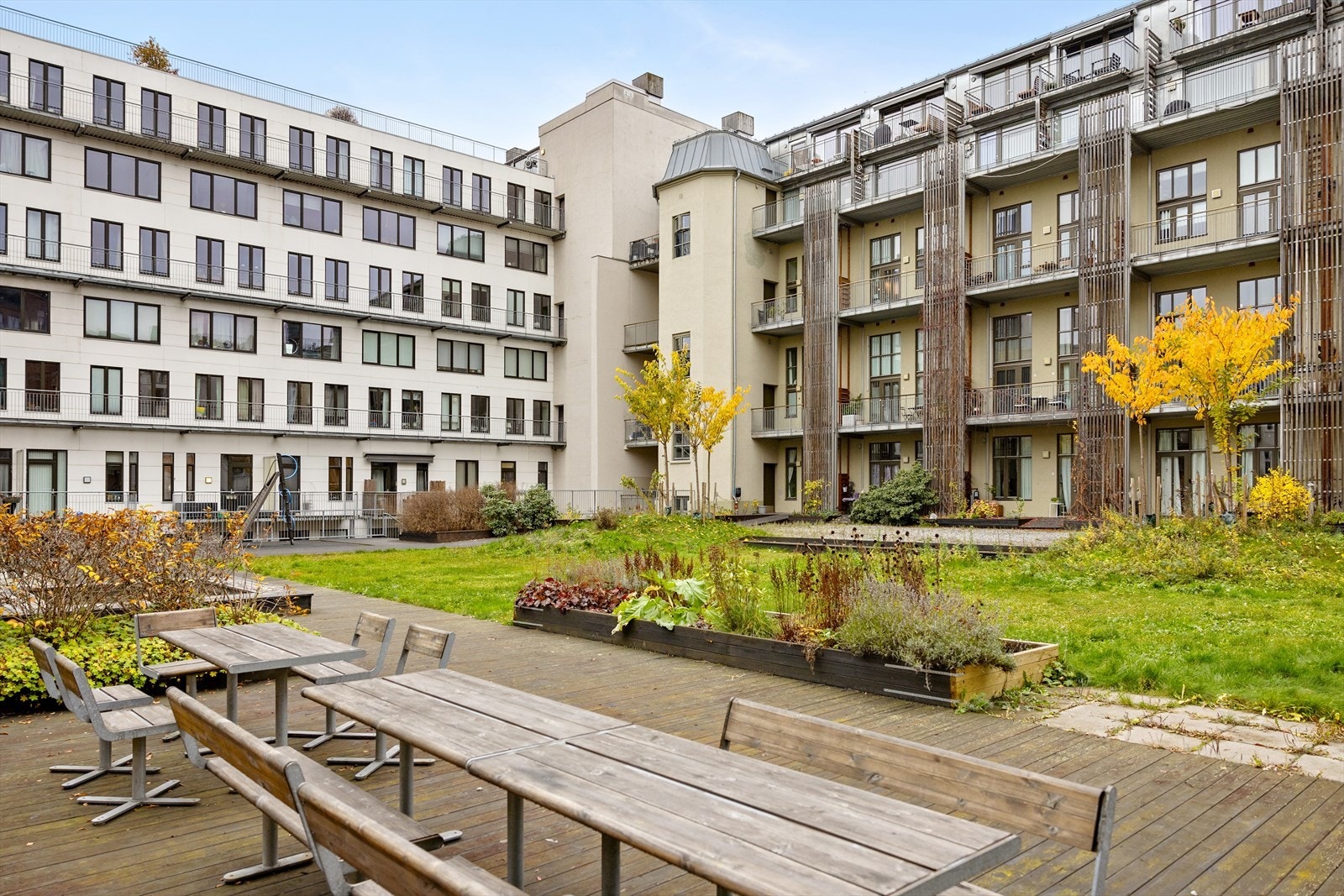 Pent opparbeidet gårdsrom med sittegrupper og beplantning. Galleribilde