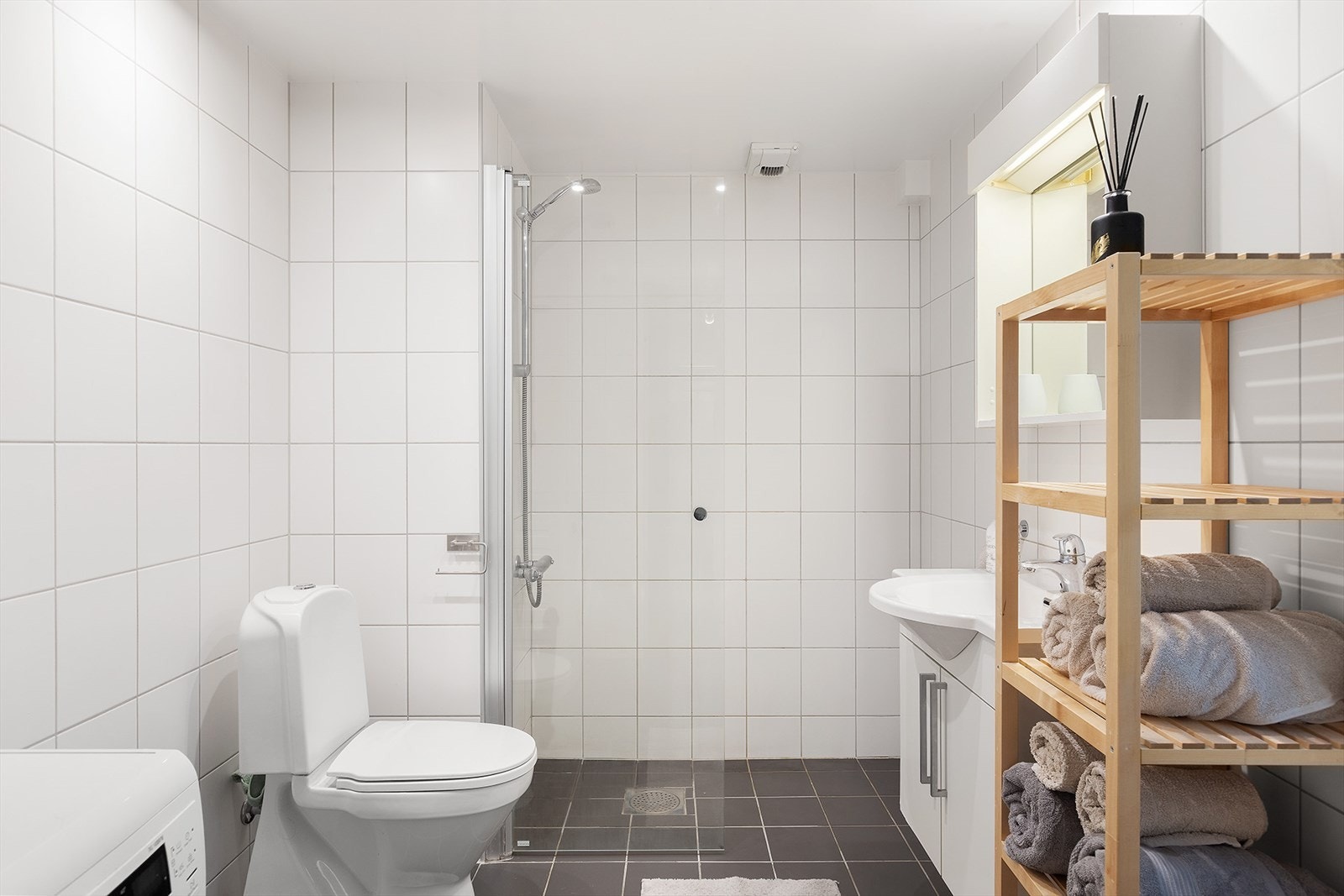 Bad er utstyrt med dusjnisje, toalett, opplegg for vaskemaskin, servant og servantinnredning. Galleribilde