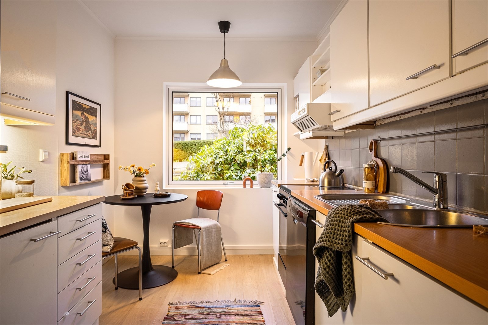 Kjøkkenet ligger i eget rom og har en praktisk og funksjonell utforming med innredning på begge sider, noe som gir gode arbeidsflater og rikelig med skapplass Galleribilde