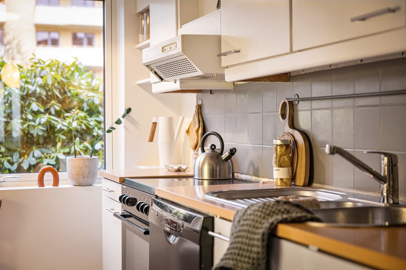 Innredningen har hvitmalt, slett utførelse med laminert benkeplate og malte fliser over benk. Galleribilde