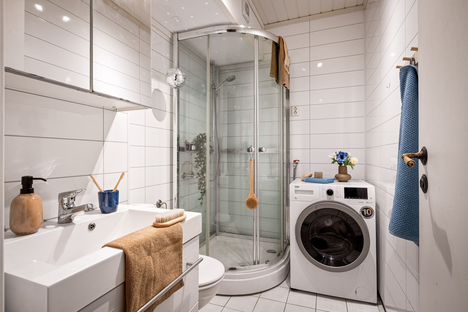 Badet har flislagt gulv og våtromsplater på vegger. Galleribilde