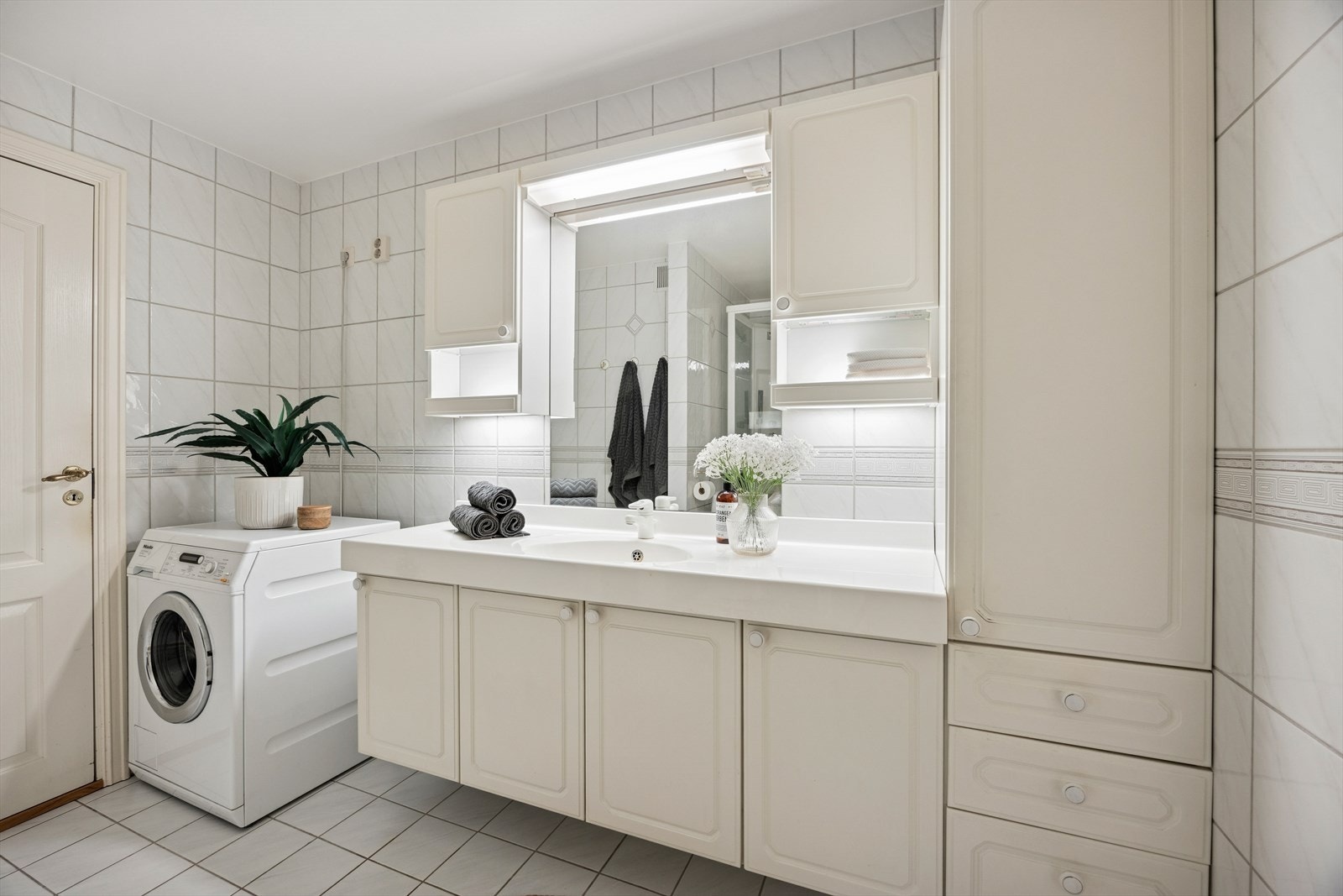 Innredning består av servant med underskap, overskap og høyskap og speil med lys over samt et dusjkabinett Galleribilde