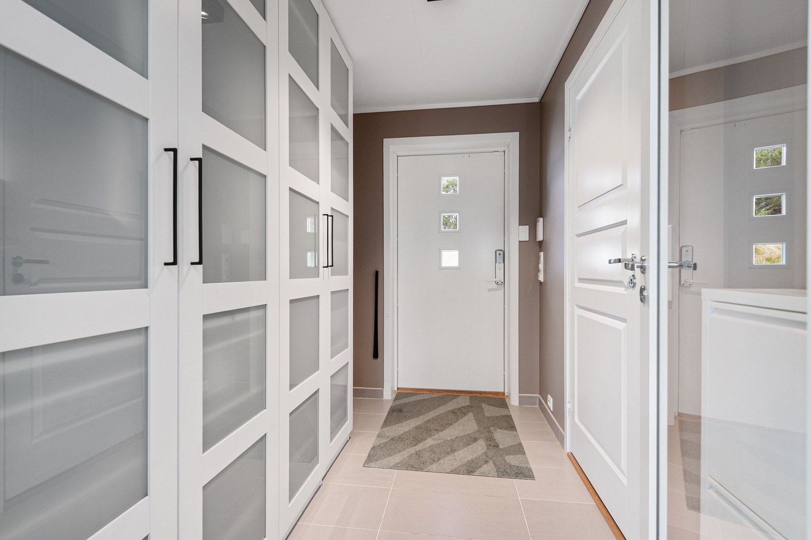 Inngangsparti/entre i hovedetasjen Hvite profilerte innerdører og innerdør med glassfelt mot stue. Galleribilde