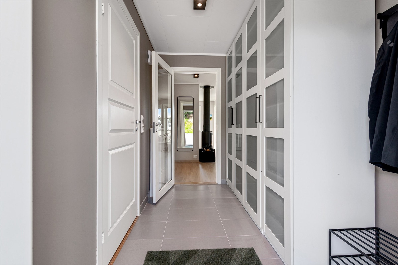 Entre/gang med flislagt gulv med gulvvarme. Stor garderobeinnredning med gode oppbevaringsmuligheter. Galleribilde