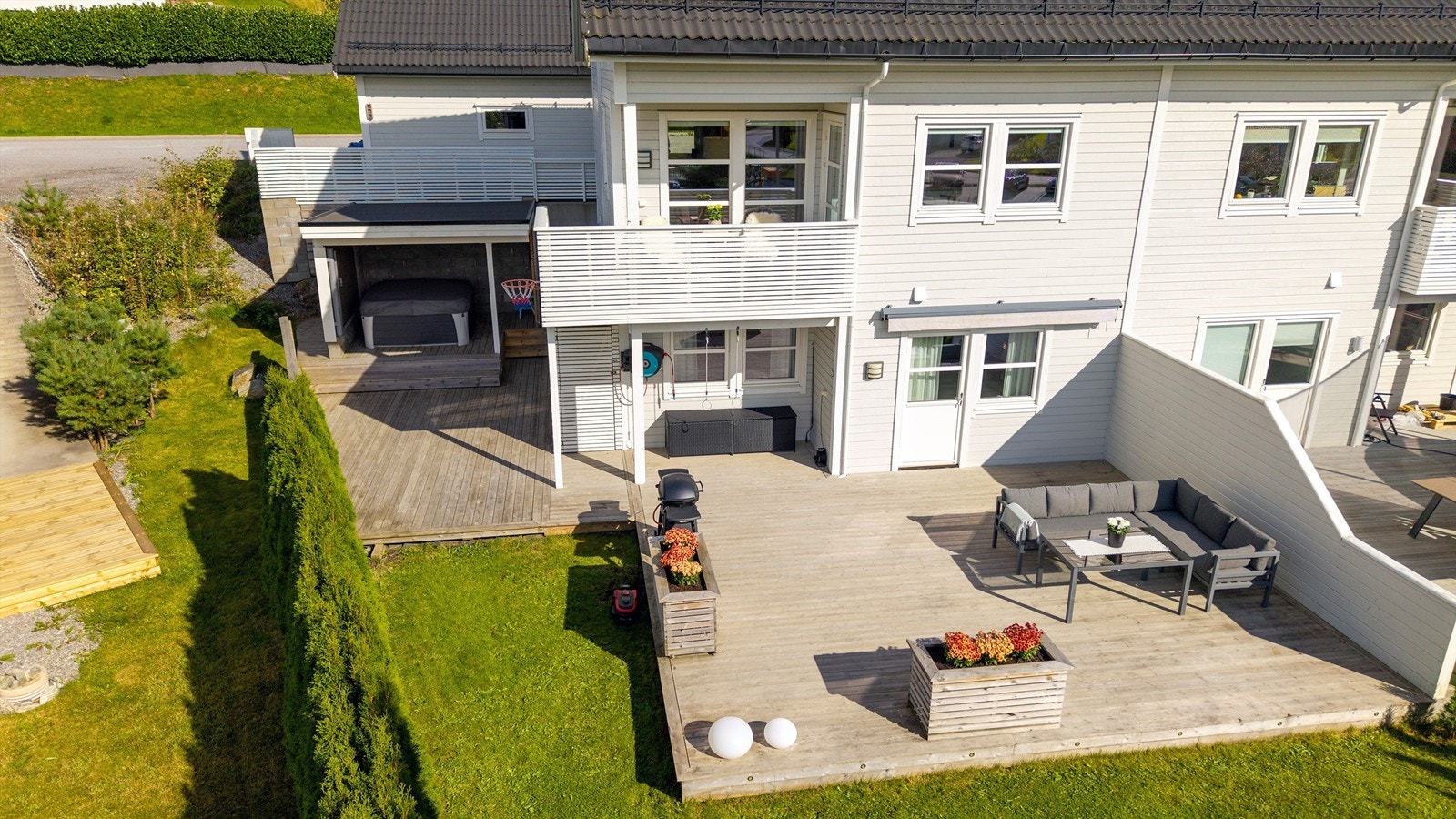 Dronebilde av fasade, markterrasse og hage Galleribilde