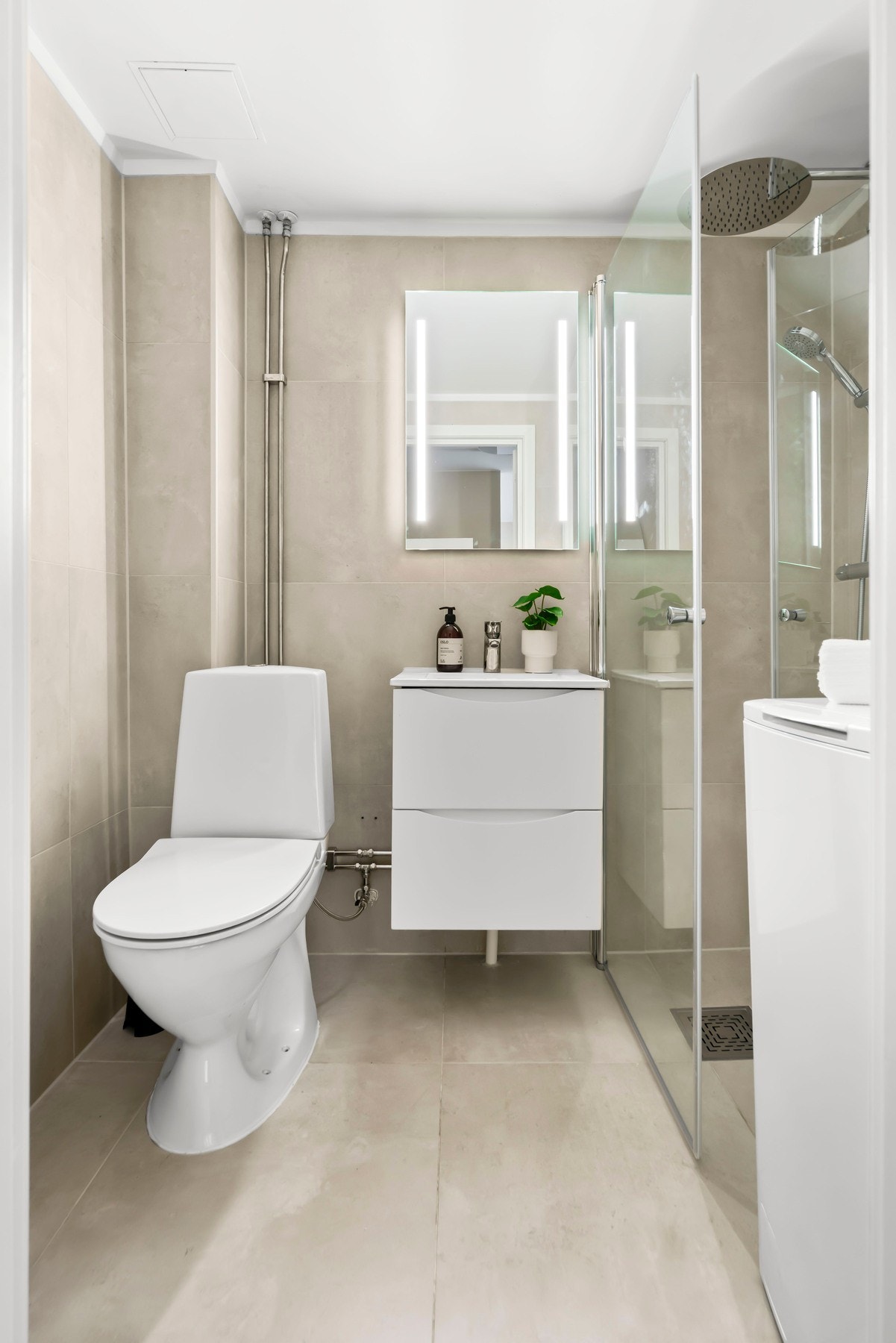 Flislagt baderom med behagelig gulvvarme og opplegg for vaskemaskin. Galleribilde