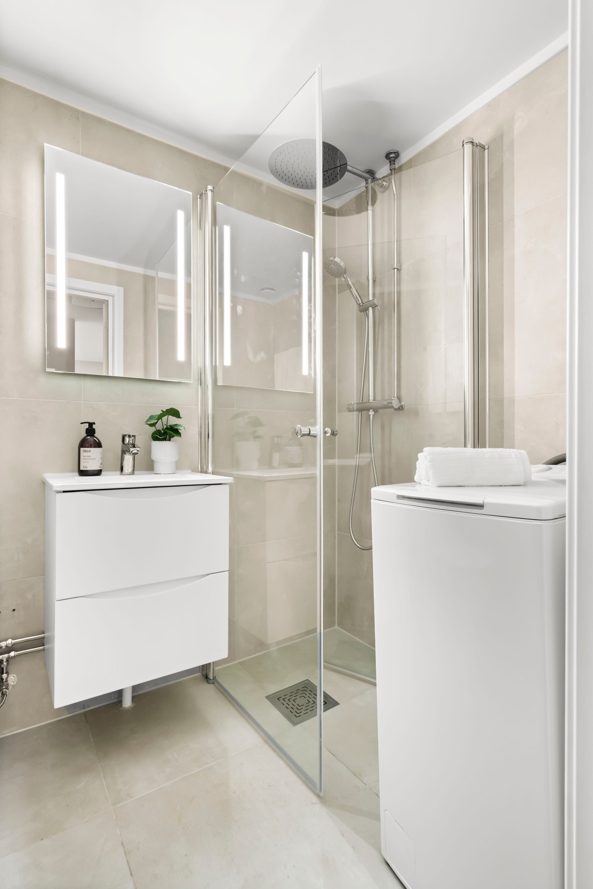 Speilskap med lysarmatur på vegg over servant. Videre er det dusjhjørne med svingdør, sluk i sone, regnfallsdusj og termostatstyrt blandebatteri. Gulvmontert toalett. Galleribilde