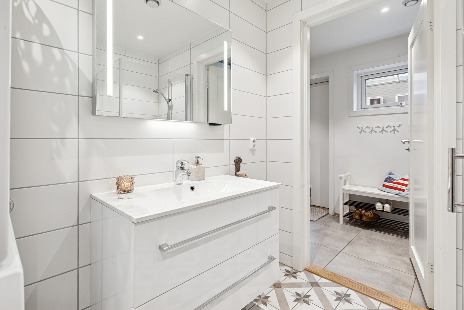 Baderom i 1.Etasje med ankomst fra gang, er fra byggeåret med flislagte overflater og varmekabler i gulv. Galleribilde