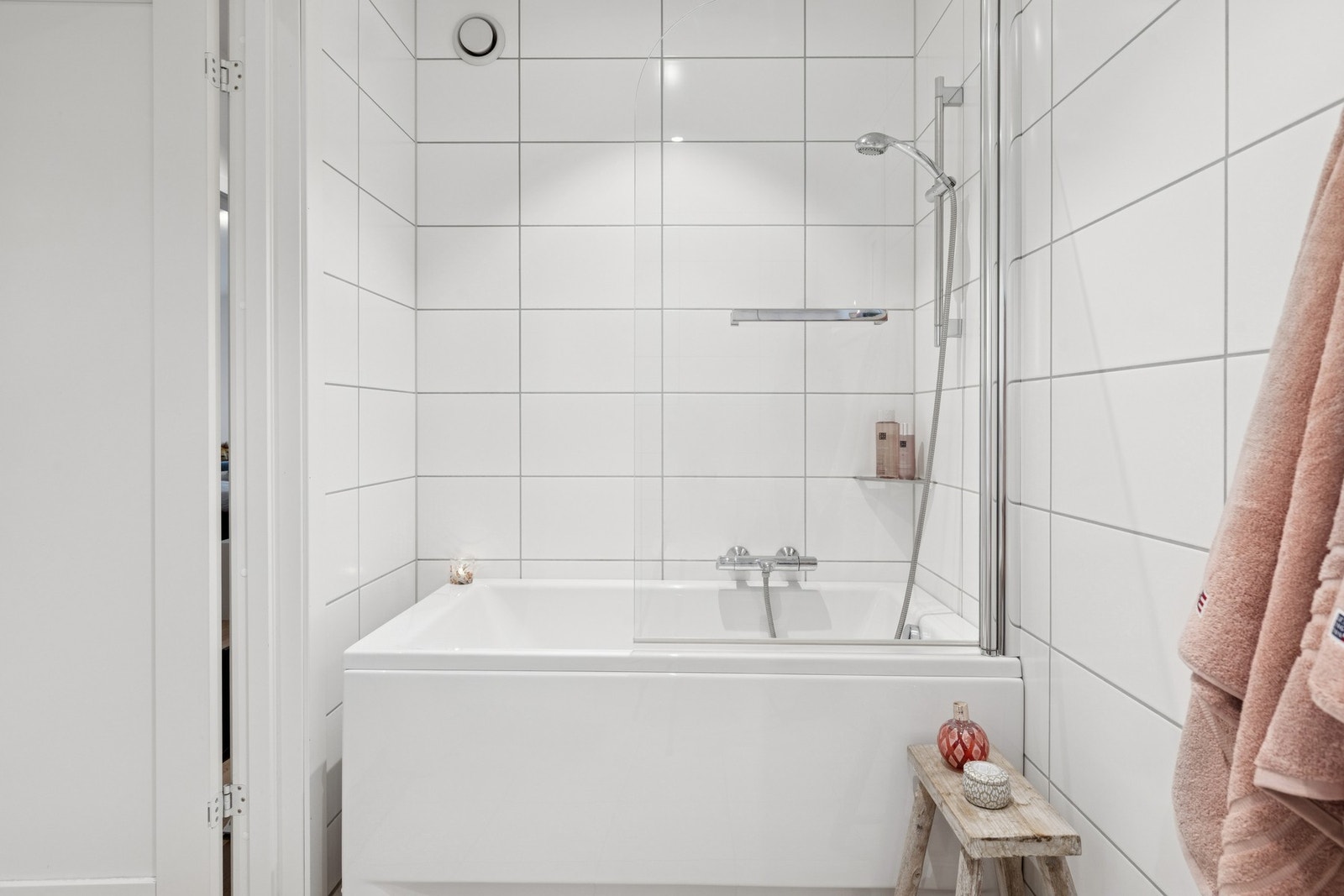 Videre har badet et badekar med glassdør. Himlingen er lyssatt med downlights. Galleribilde