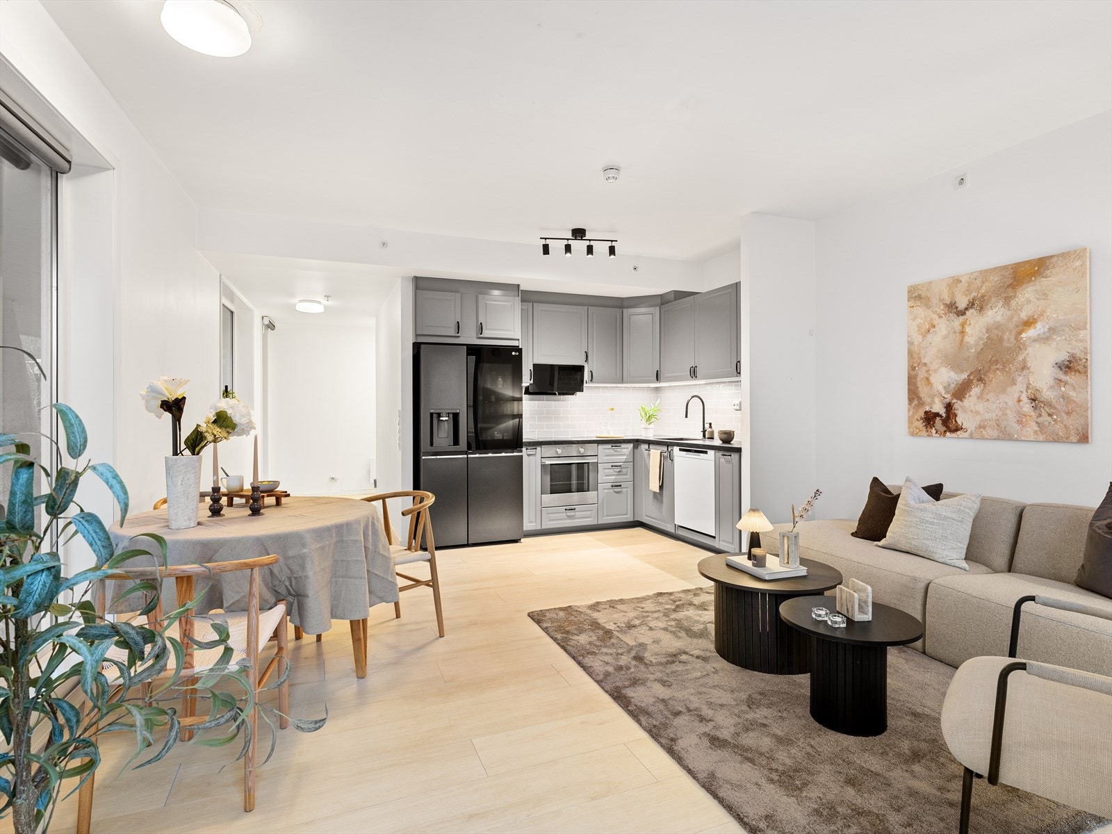 Stue og kjøkken i åpen løsning. Ny laminat på gulv og lyse vegger. Galleribilde