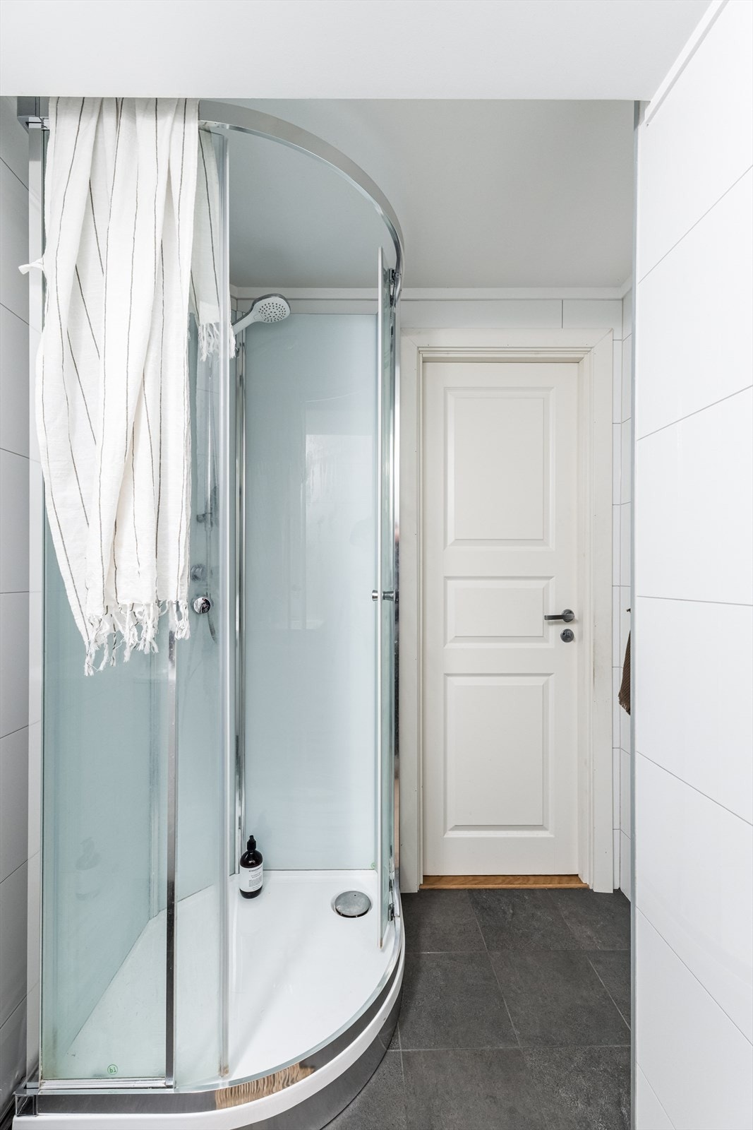 Badet er innredet med heldekkende servant og overskap med speil og lys, frittstående toalett, dusjkabinett. Galleribilde