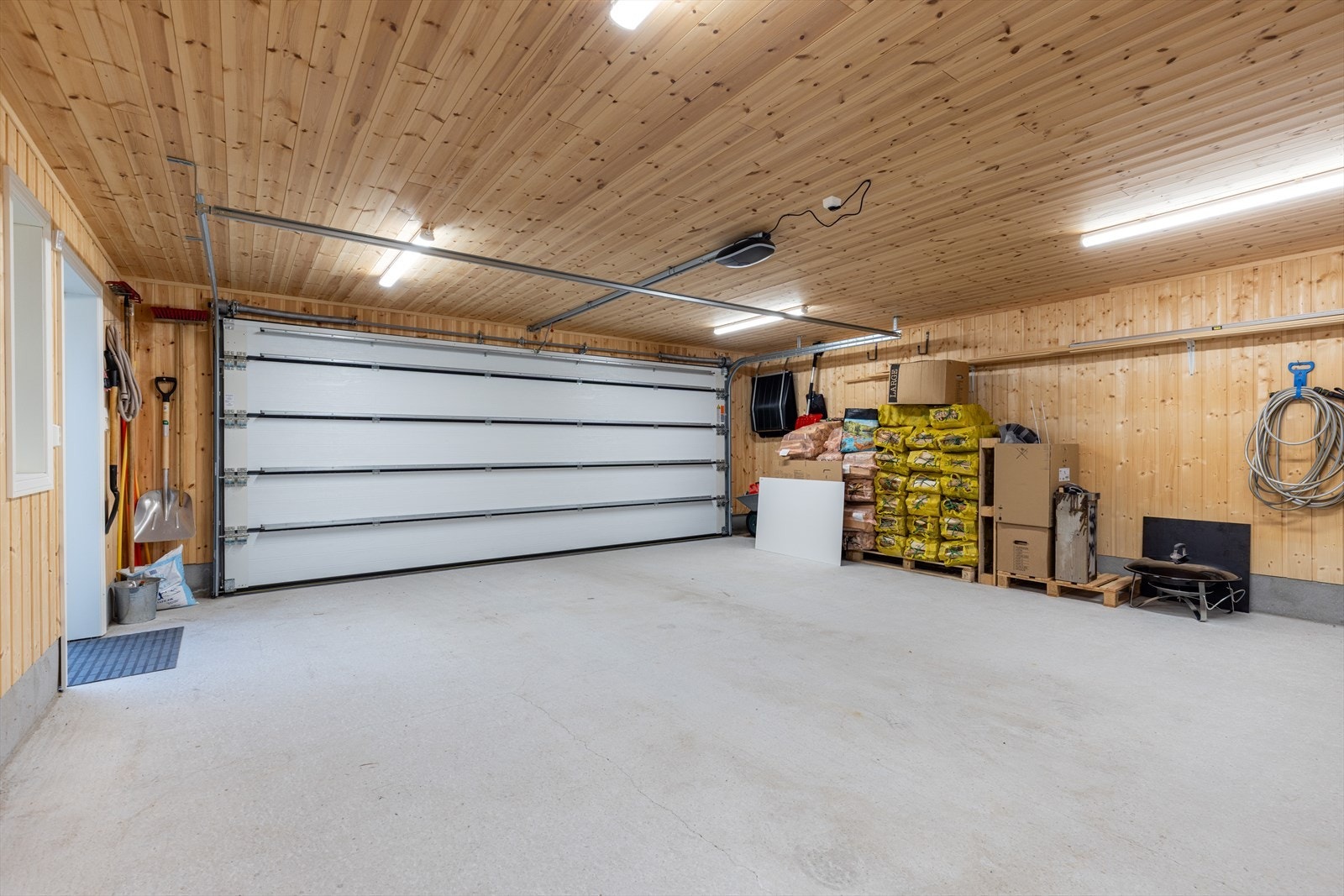 Det er gode parkeringsmuligheter på gruset gårdsplass, samt i den doble garasjen med sidedør og elektrisk leddport i stål/aluminium. Galleribilde