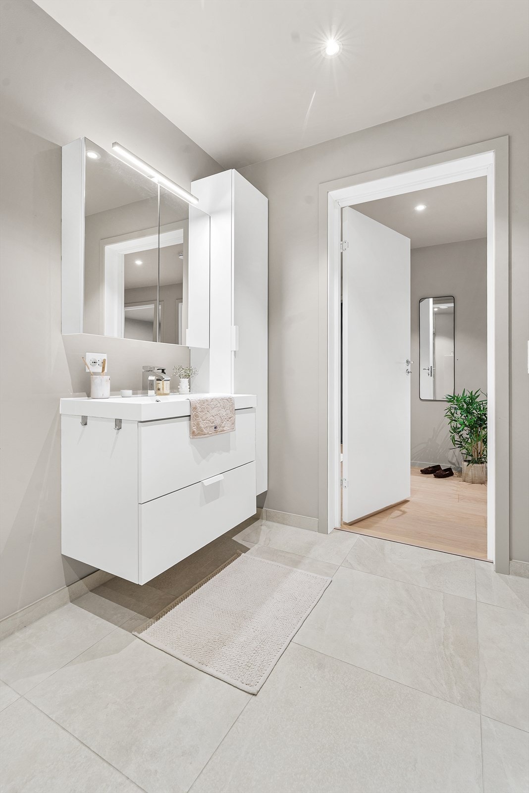 Lyst og moderne baderom med romslig oppbevaring. Flott flislagt gulv og stilrent design Galleribilde