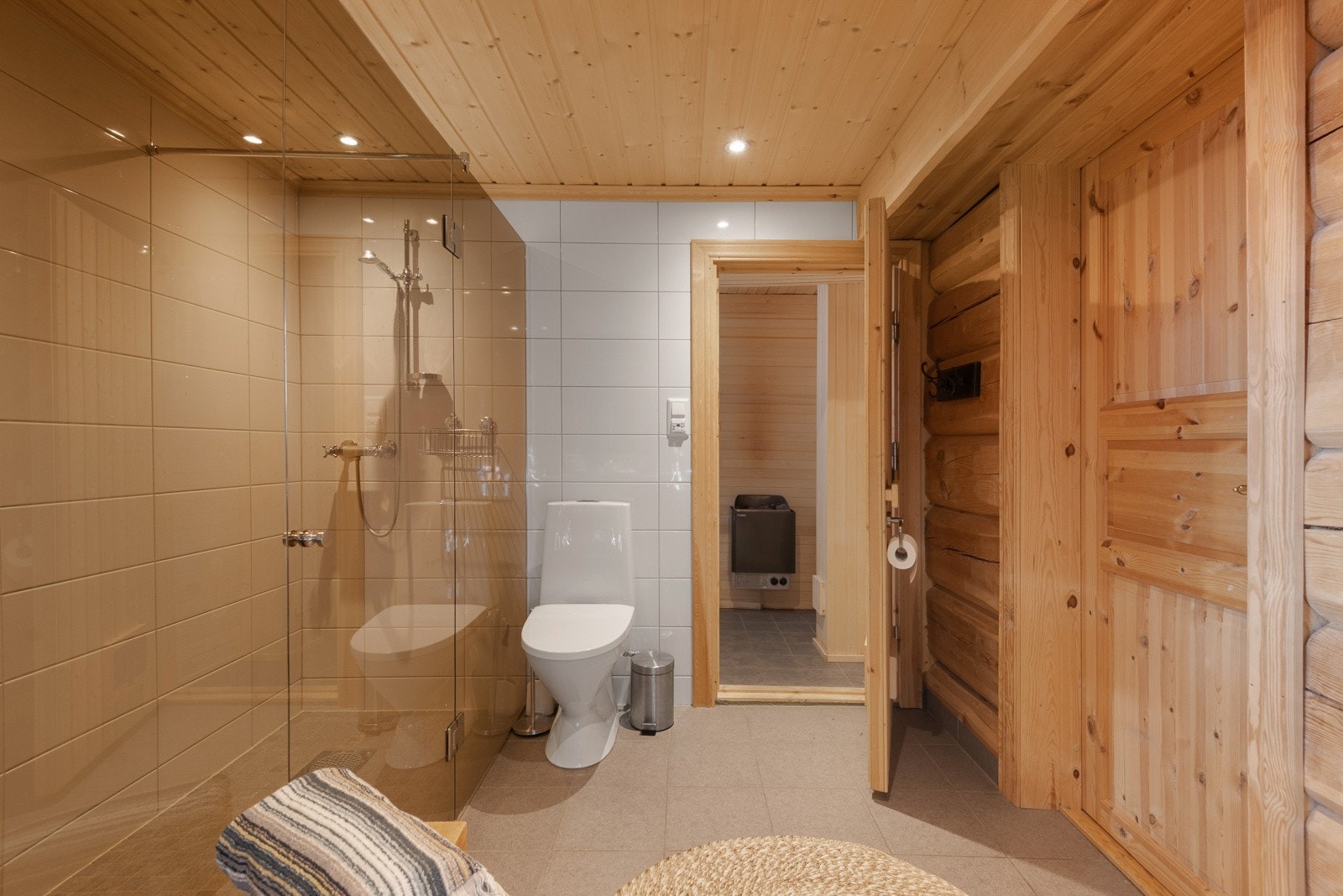 Dusjområdet har flislagte vegger, glassvegg og veggmontert dusjsett med hånddusj. Galleribilde