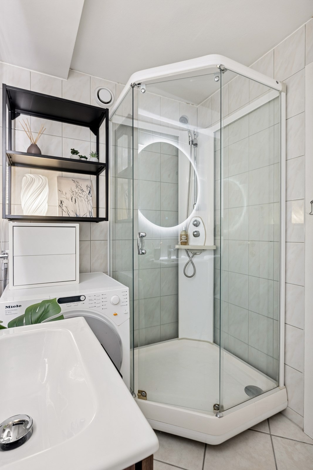 Badet er utstyrt med dusjkabinett, gulvstående toalett og opplegg for vaskemaskin. Galleribilde