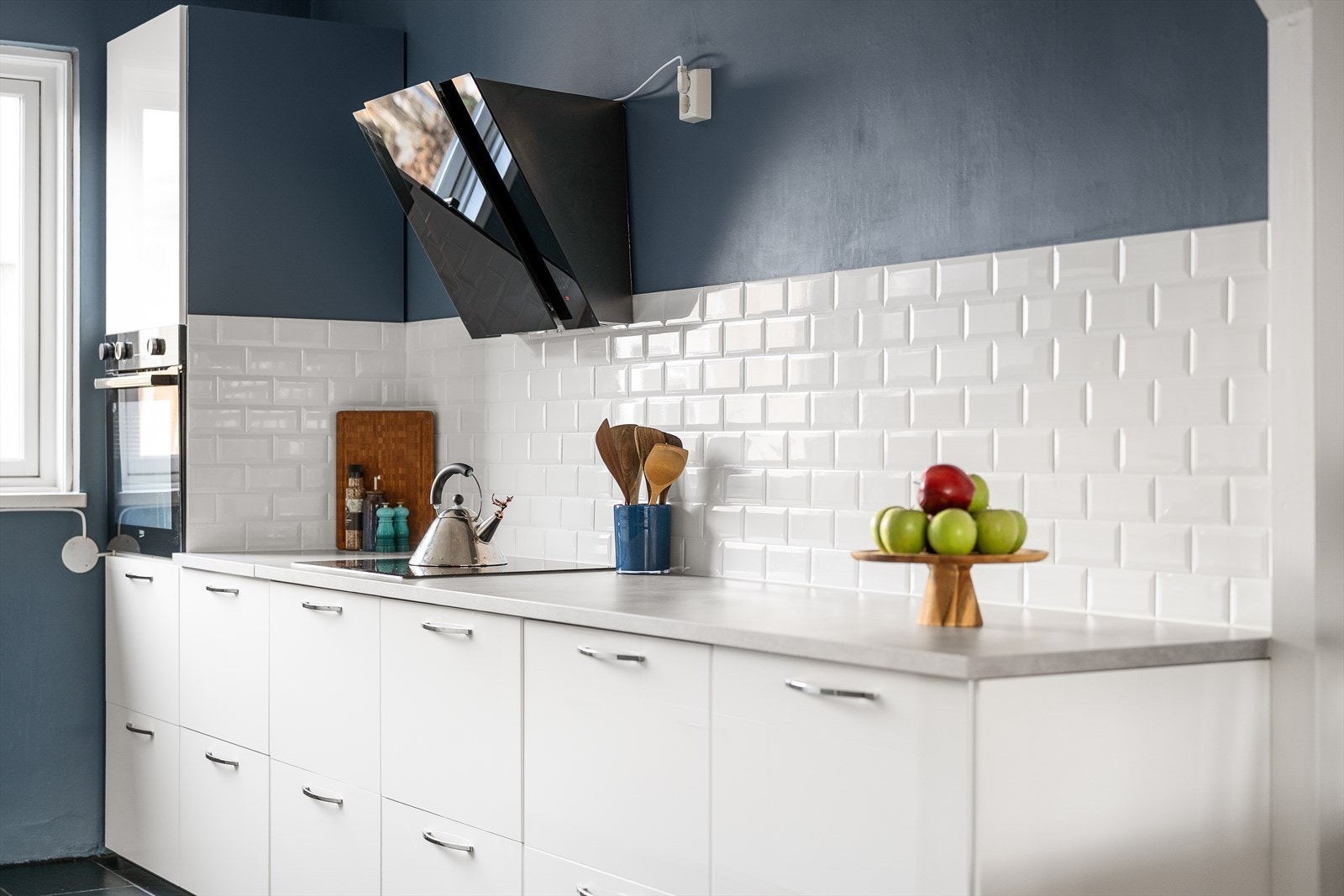 Kjøkkeninnredningen har glatte fronter, laminatbenkeplate og integrert platetopp. Galleribilde