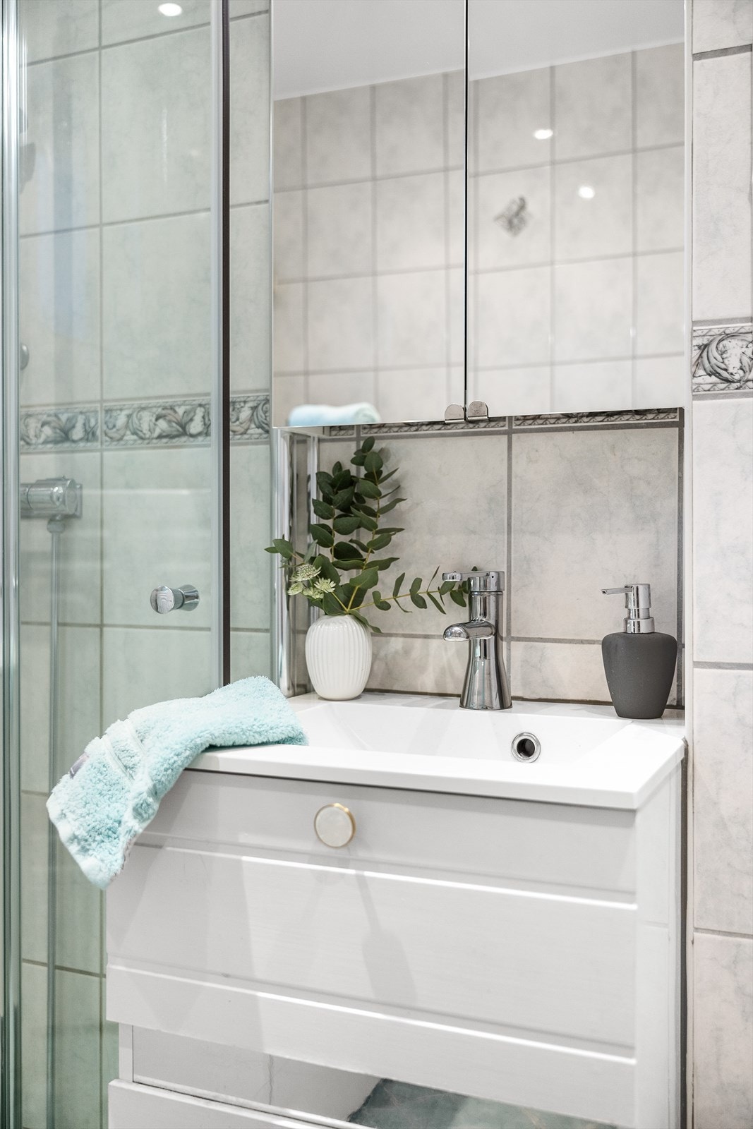 Rommet er utstyrt med dusj med glassdører og har opplegg for vaskemaskin. Servantinnredning med ettgreps blandebatteri og speilskap med belysning. Galleribilde