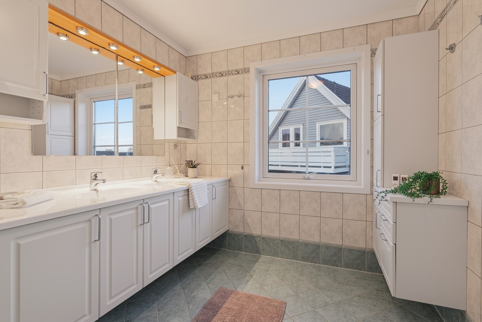 Store vinduer gir naturlig lys og en behagelig atmosfære. Her får du et praktisk og komfortabelt bad med rikelig plass til hele familien Galleribilde